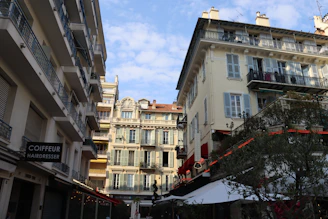 Buildings line a street with a blue sky above