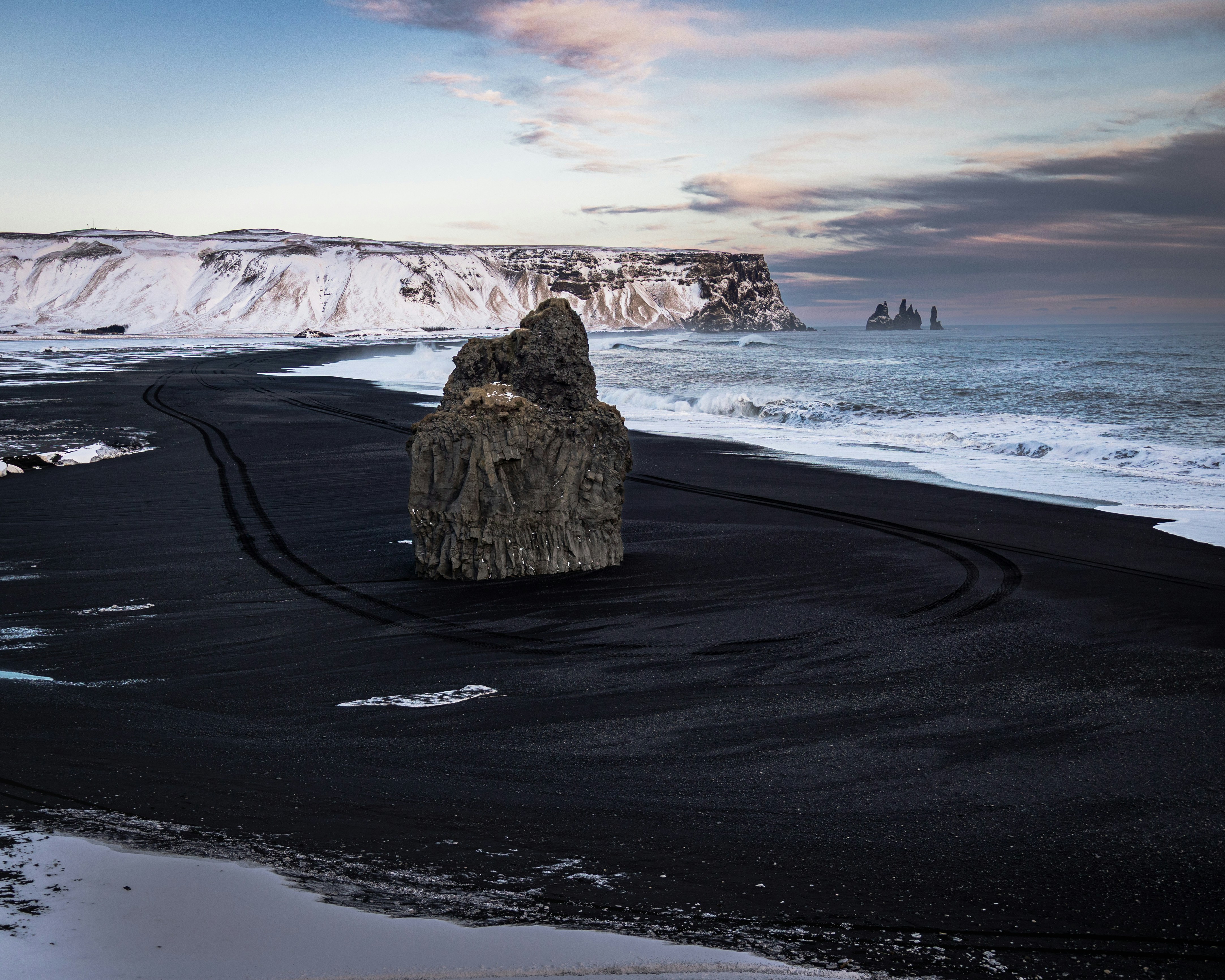 Dramatic rock formation on a black sand beach