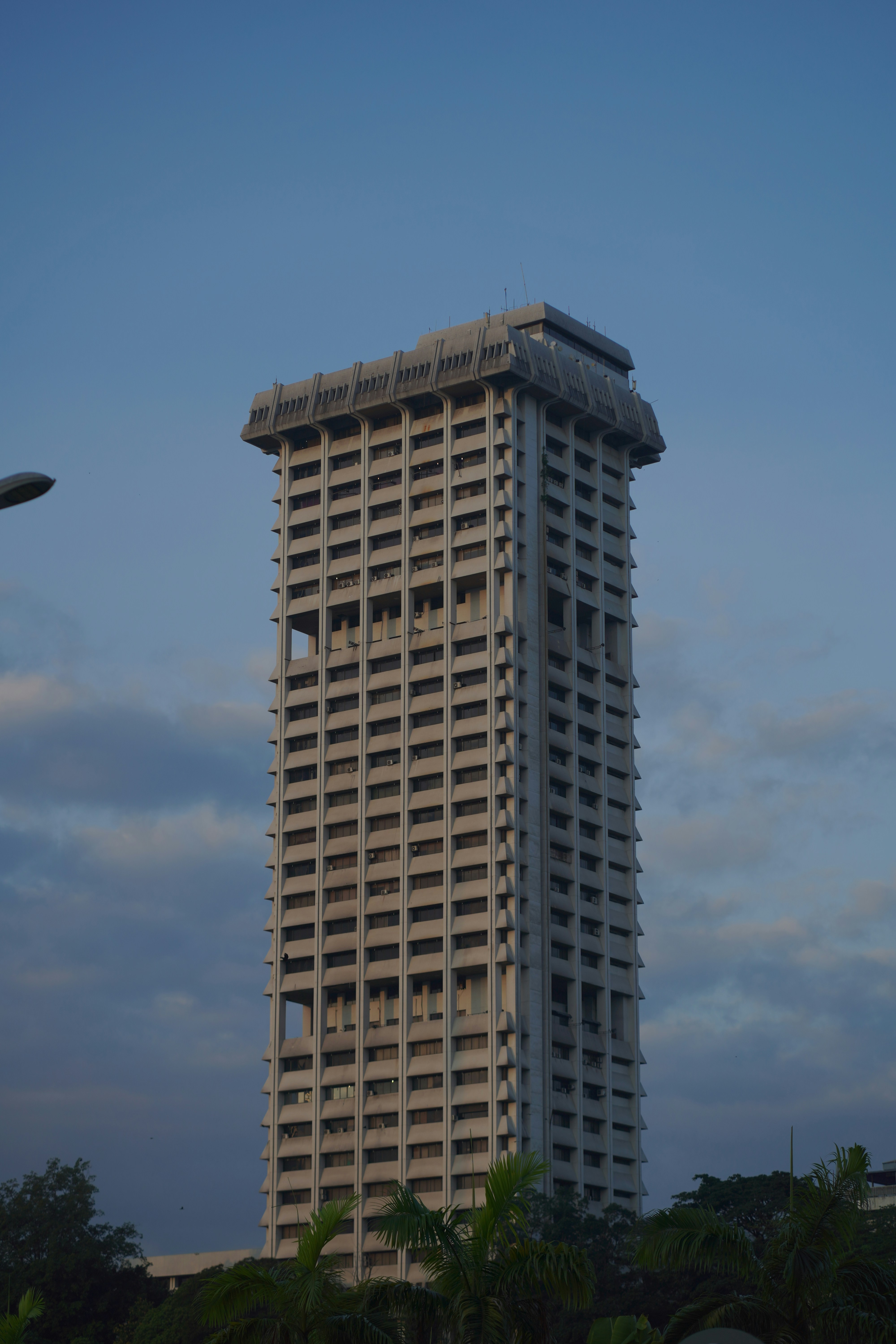 Um arranha-céu alto e moderno contra um céu azul.