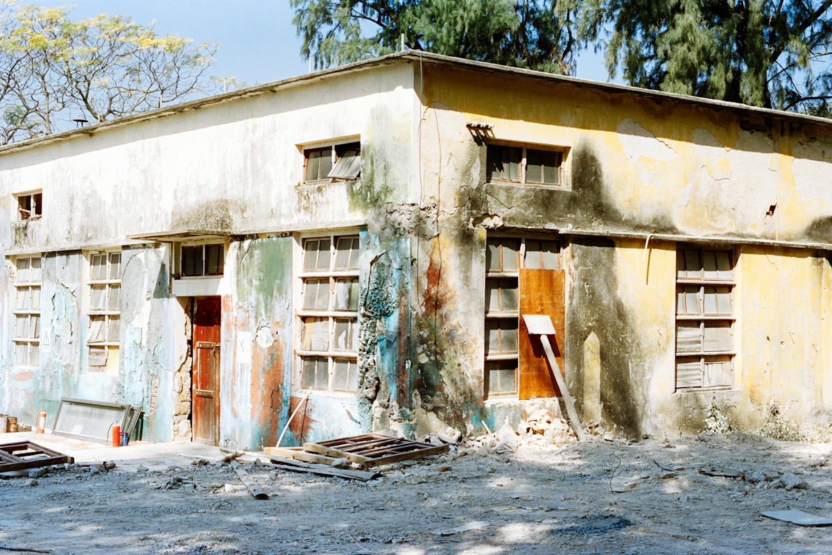 Weathered derelict building exterior with peeling paint before painting