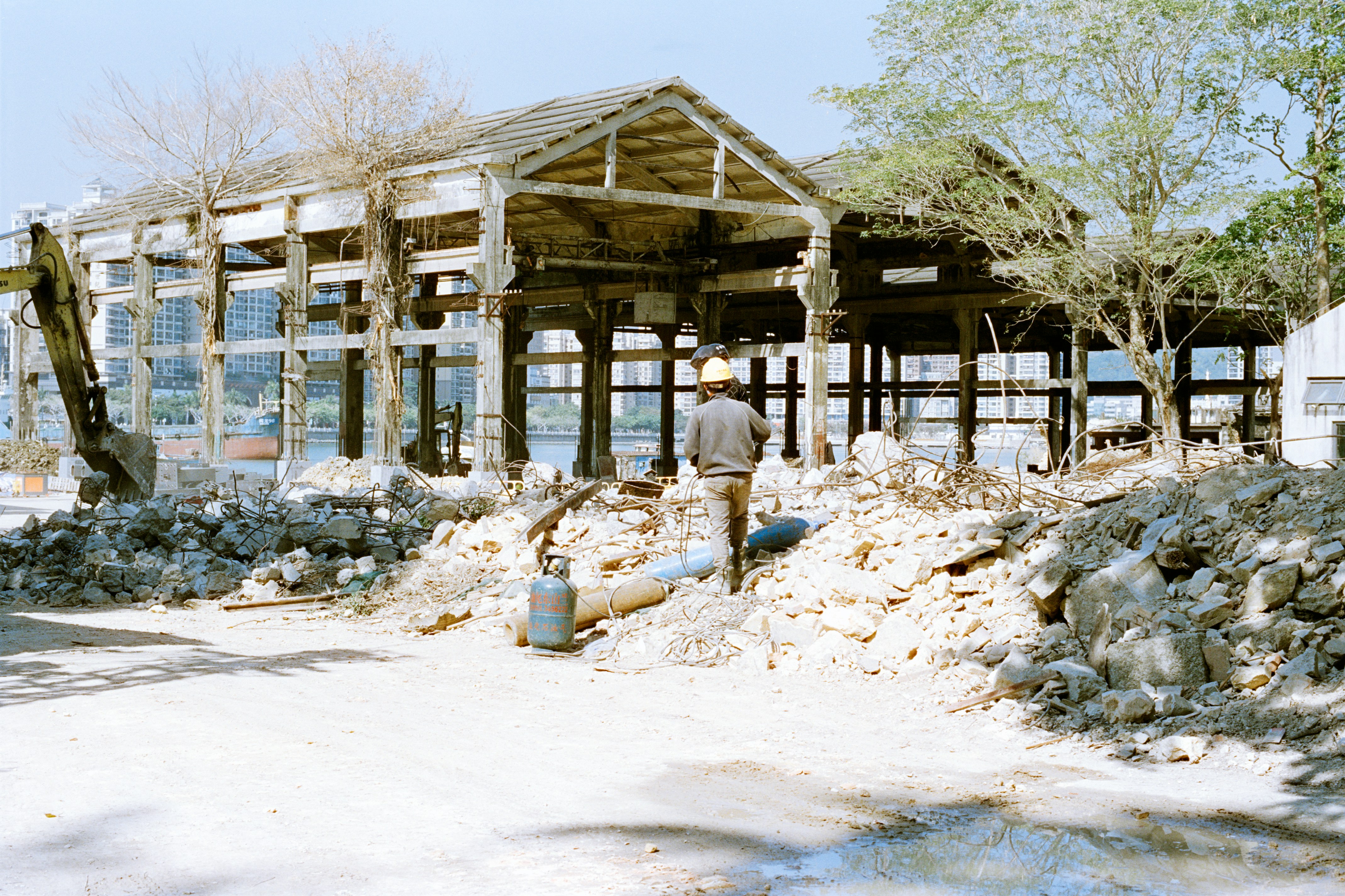 Demolition site with a person walking near rubble.