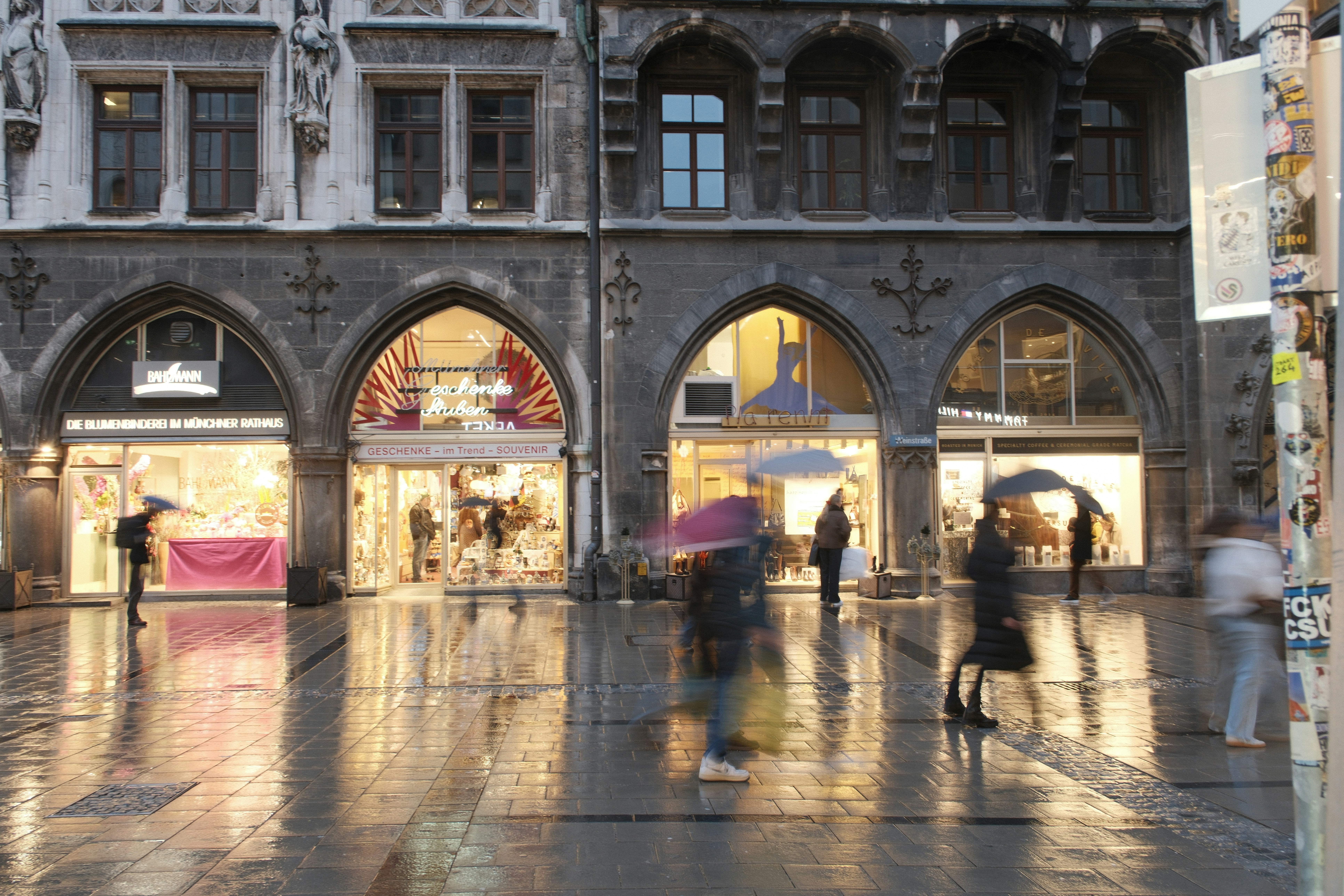 People with umbrellas walk on wet street in city