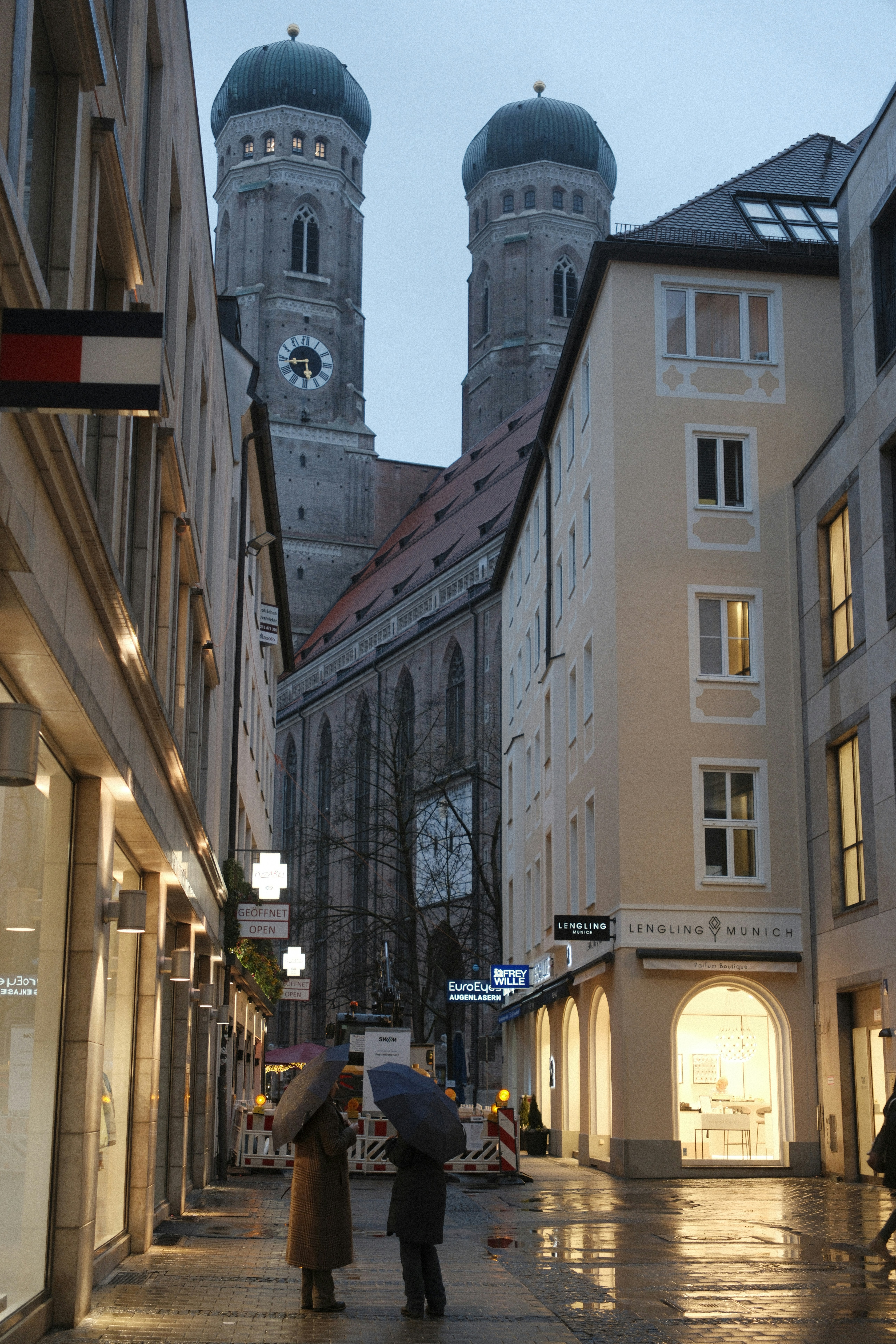 Two people with umbrellas on a wet city street