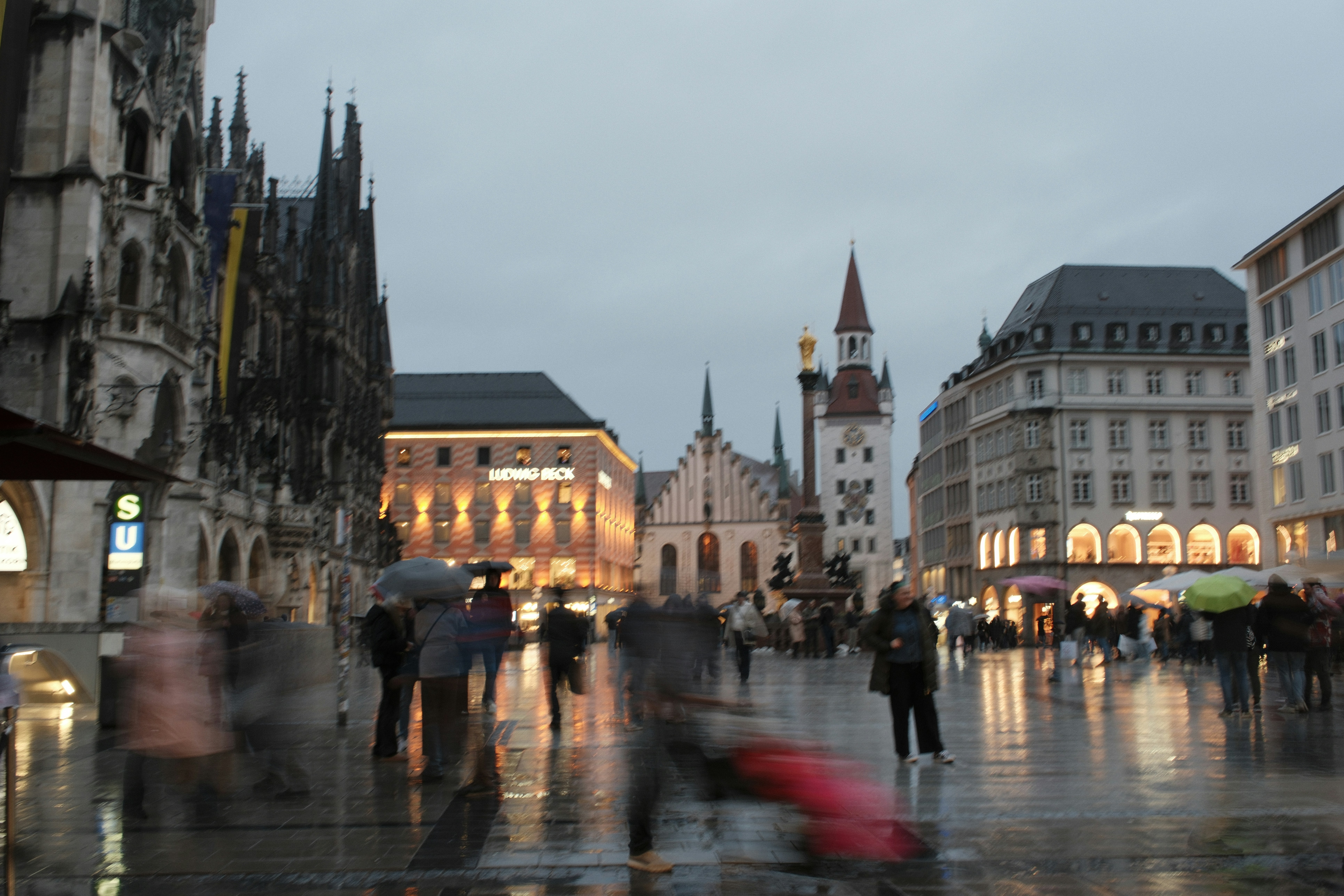 People with umbrellas in a rainy city square