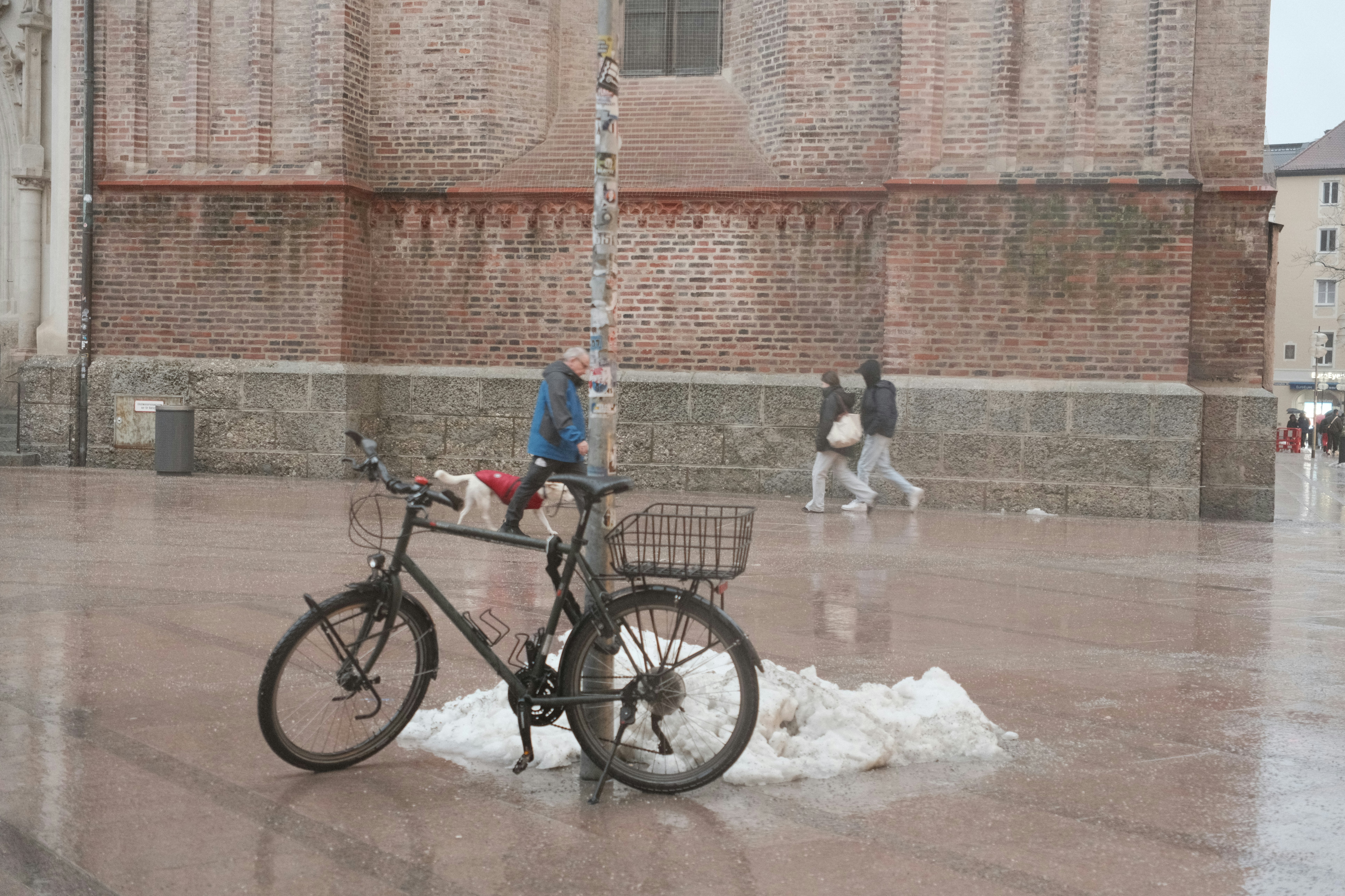 Bicycle parked on a wet city square with building
