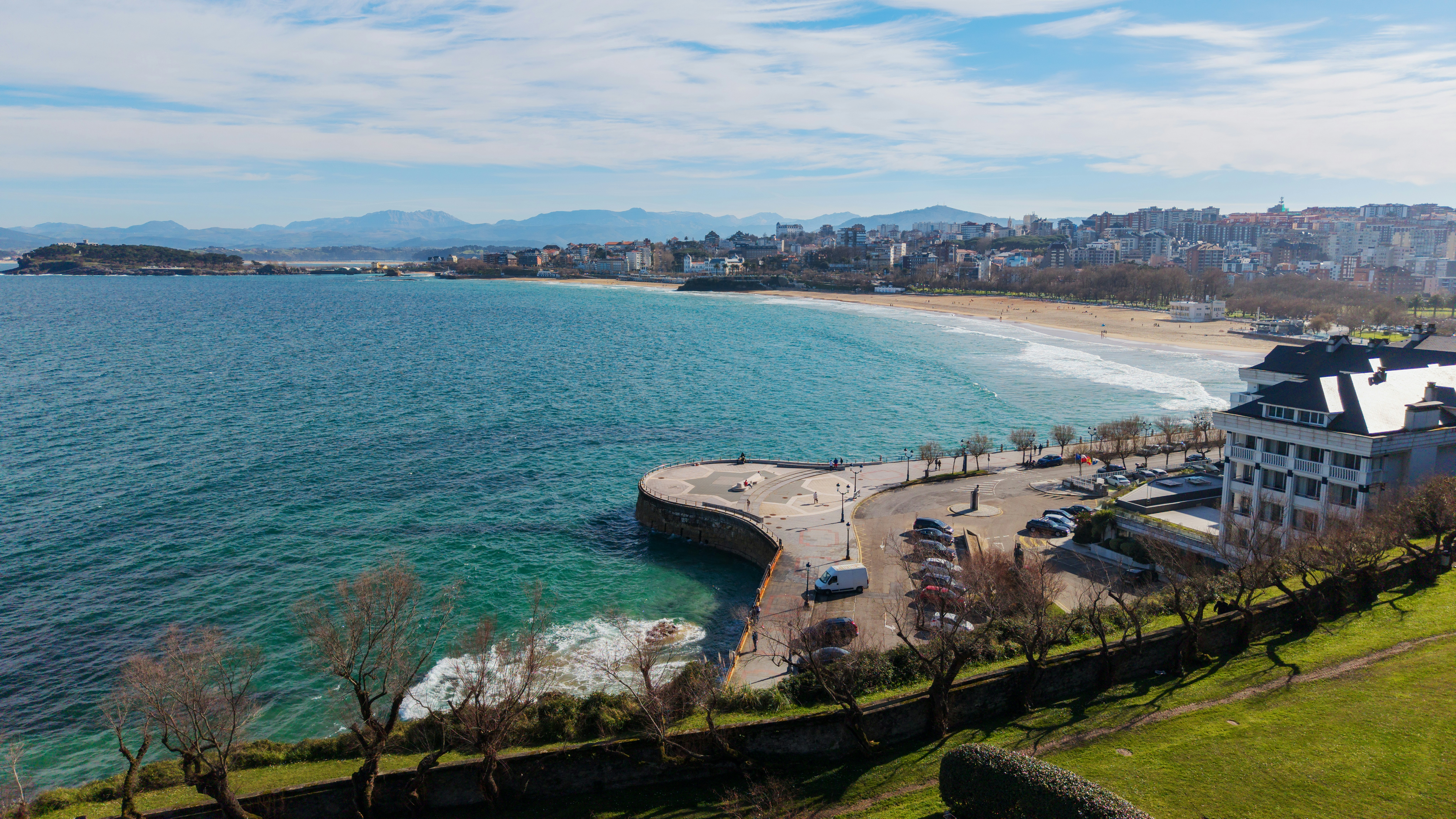 Coastal city with a crescent-shaped beach and blue ocean.