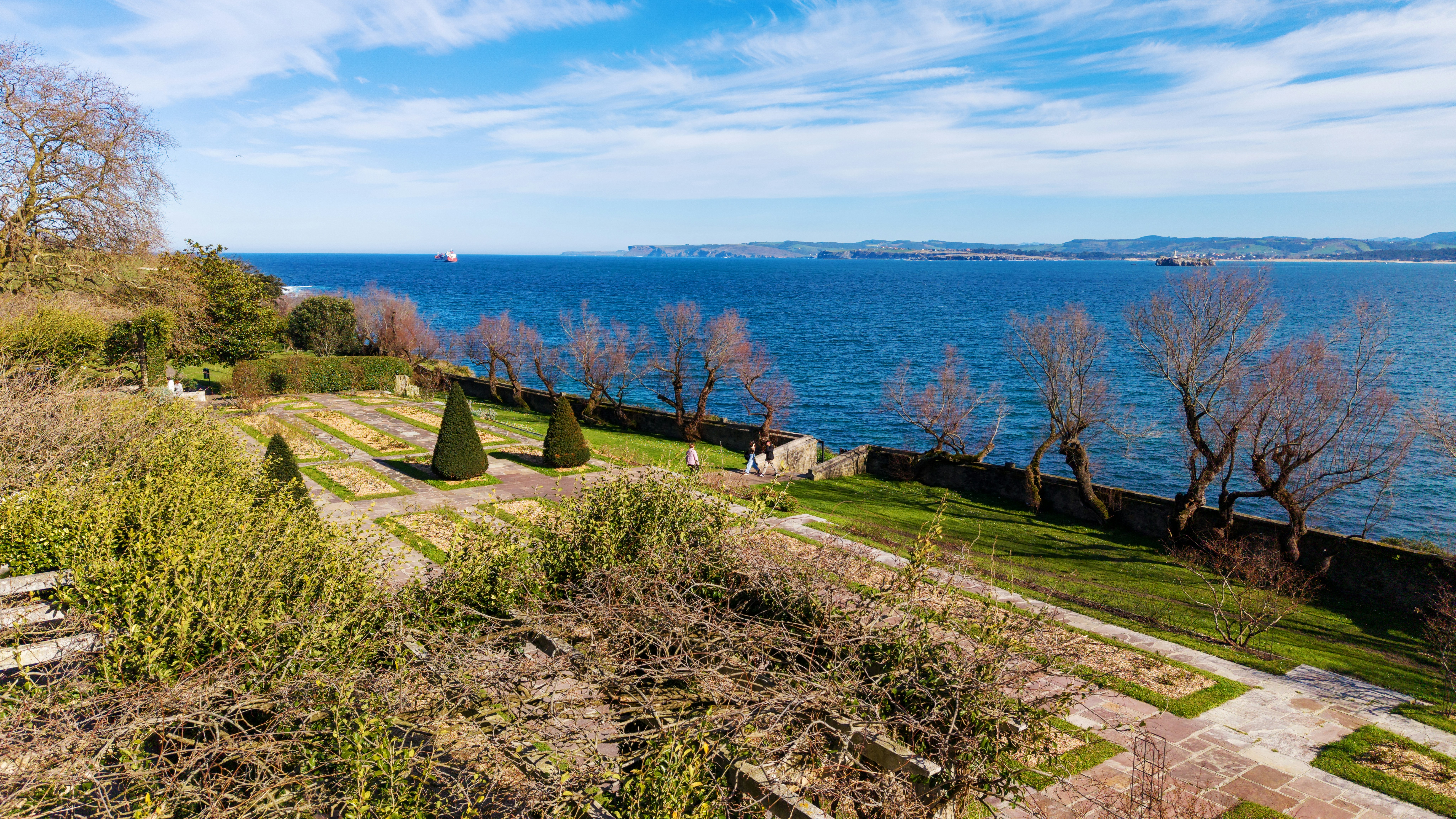 Garden overlooking a vast blue ocean under a bright sky