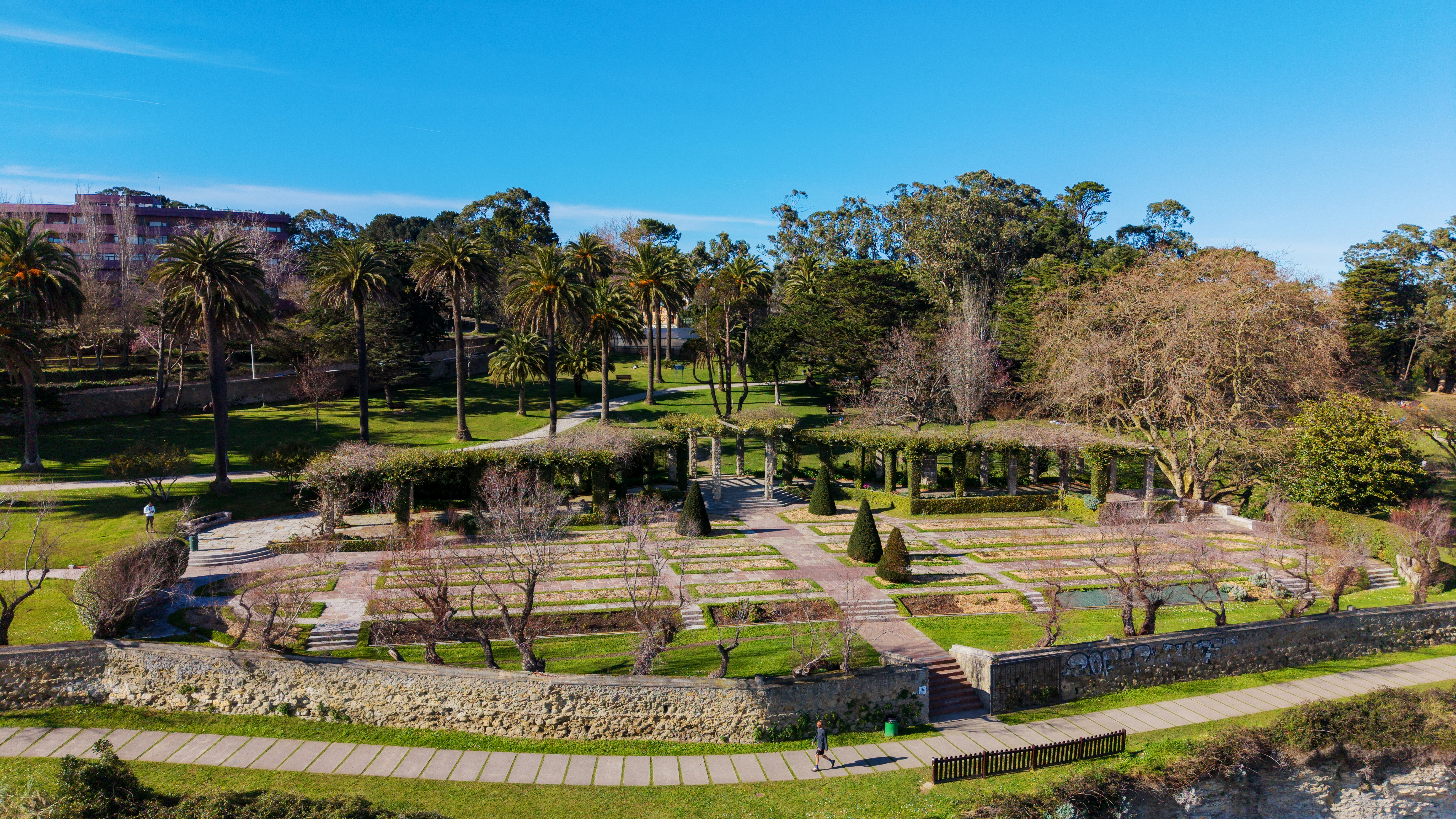 Lush green park with trees and stone walls