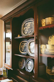 Antique china displayed in a wooden cabinet