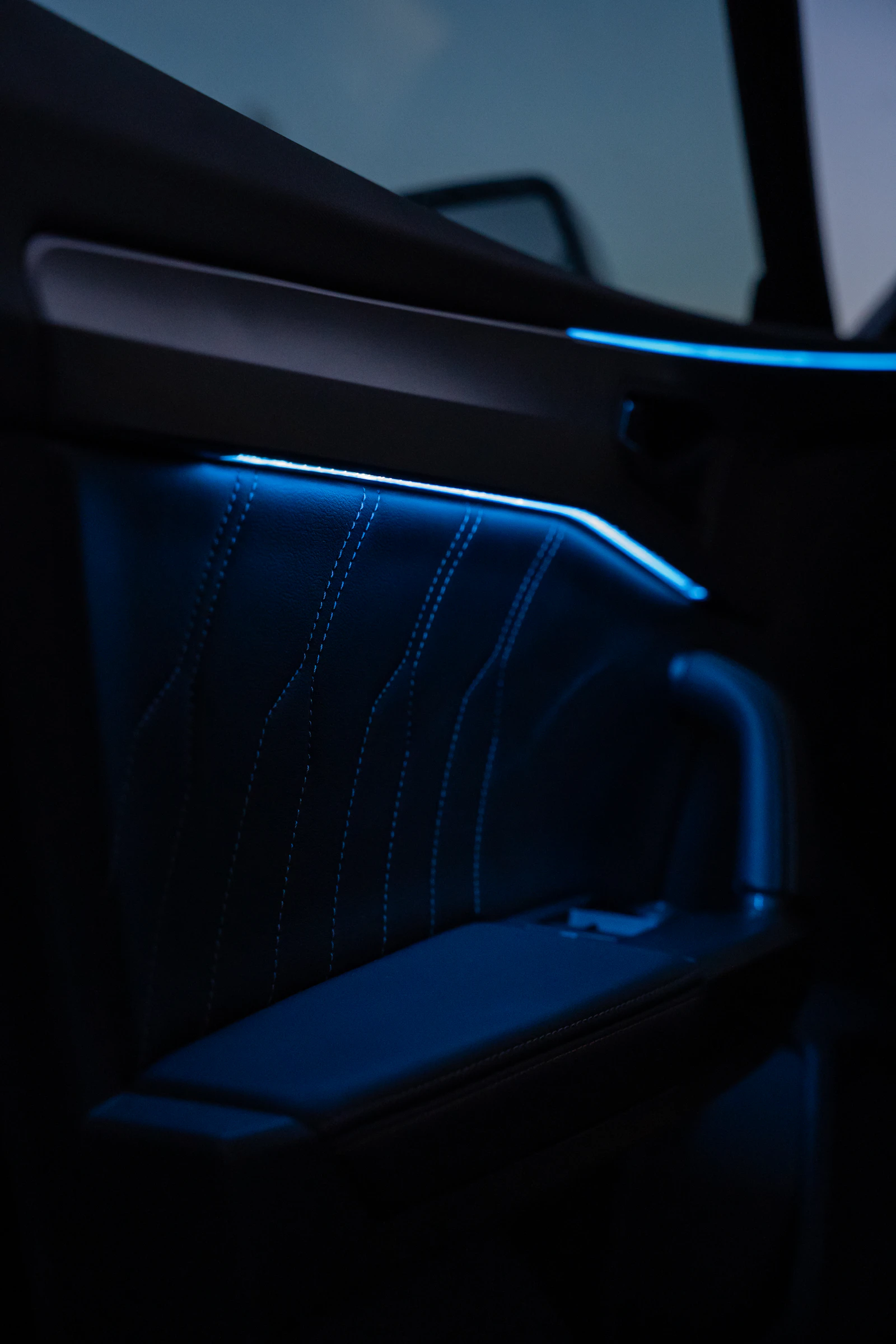 Luxury car door panel with blue ambient interior lighting