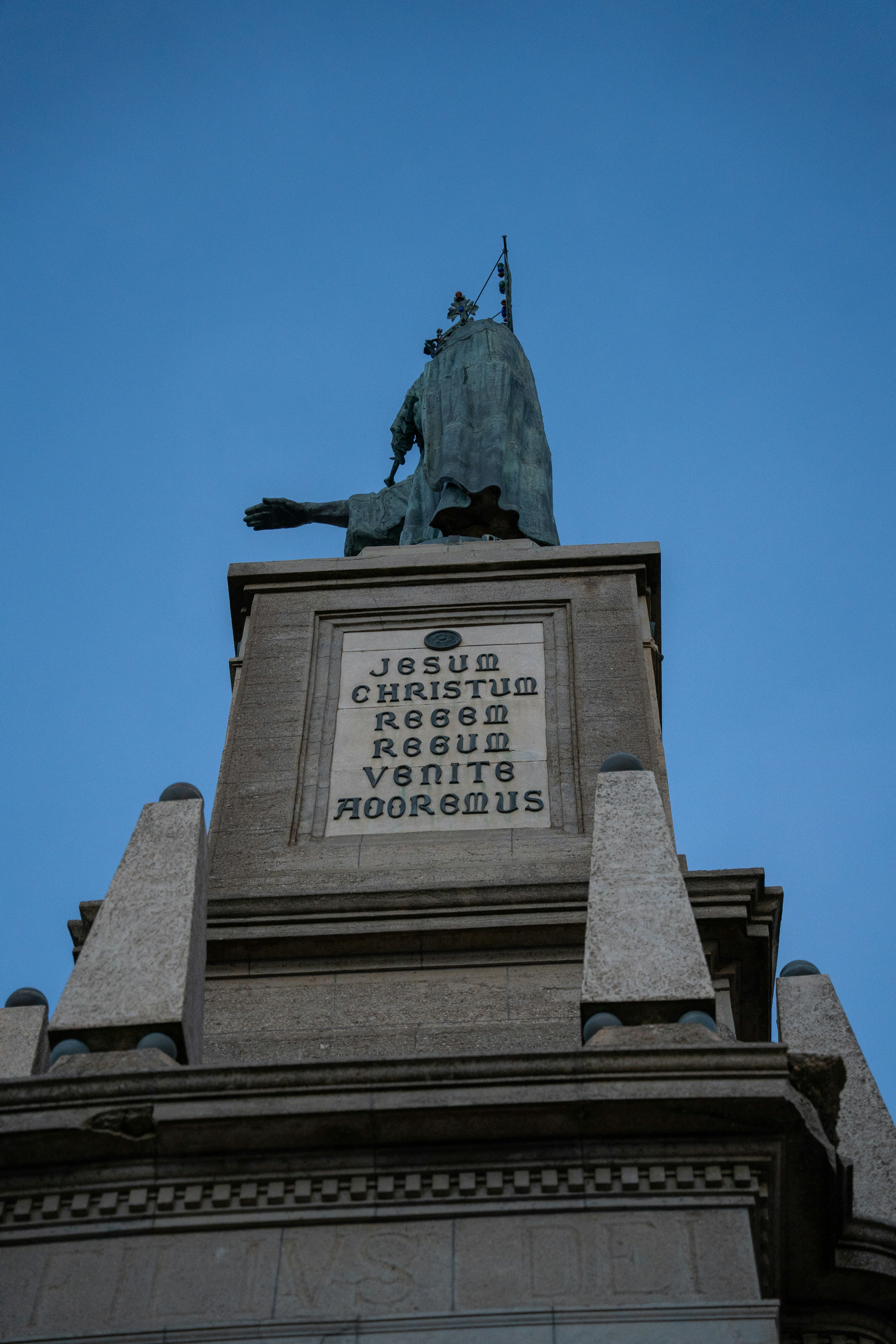 Estátua de um rei em um pedestal contra o céu azul