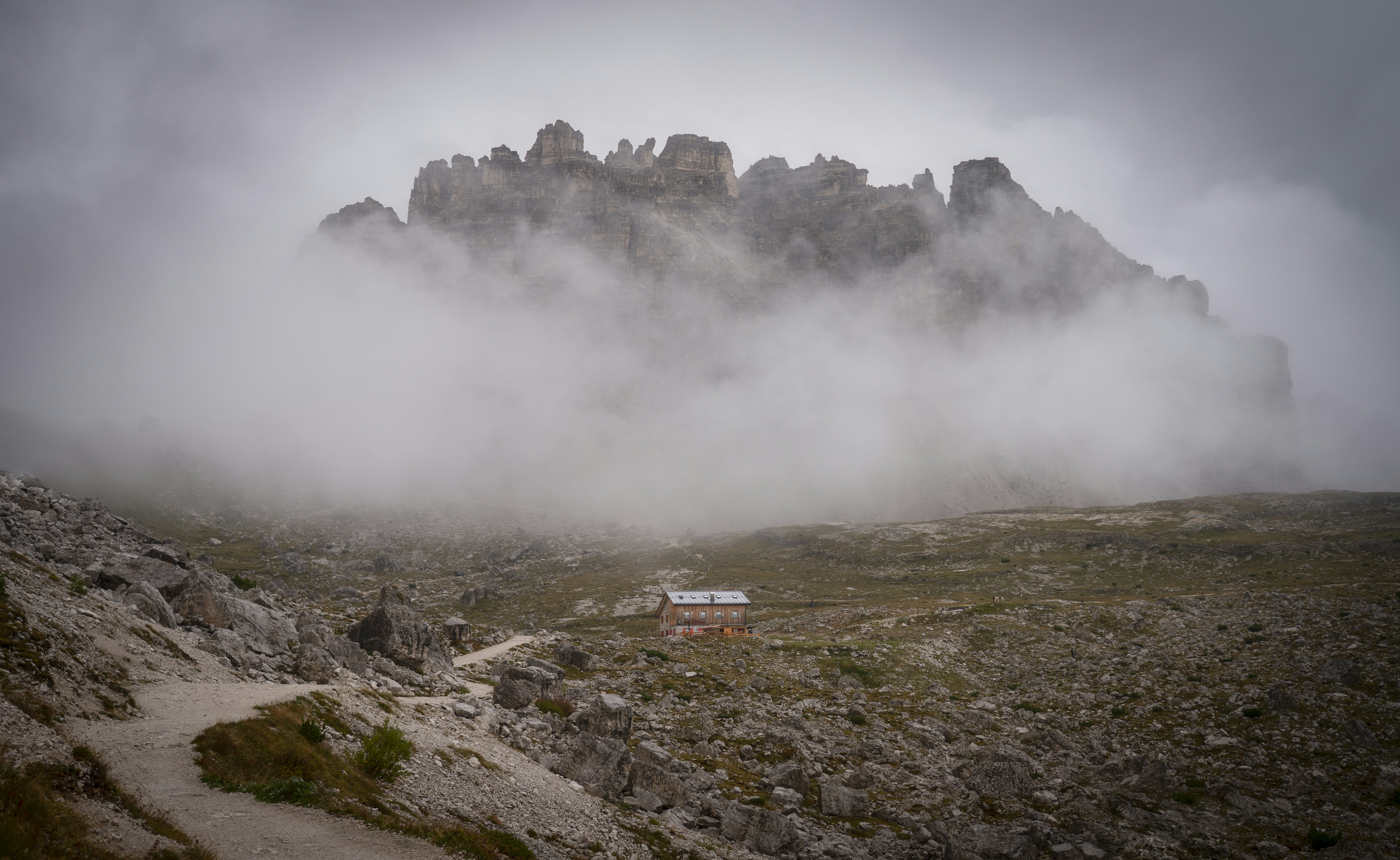 Une petite cabane nichée sous des sommets brumeux de montagnes.