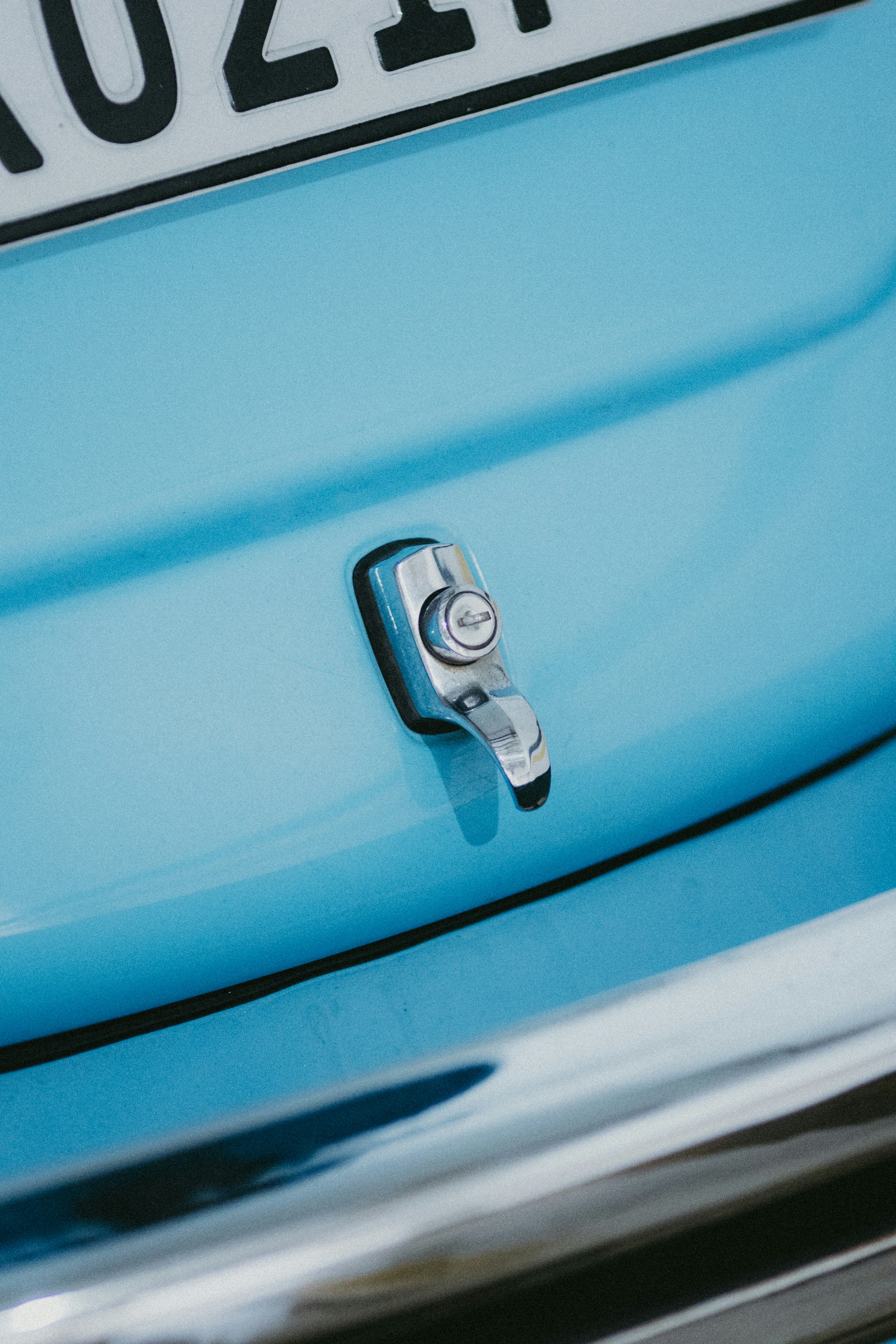 Close-up of a chrome emblem on a blue car