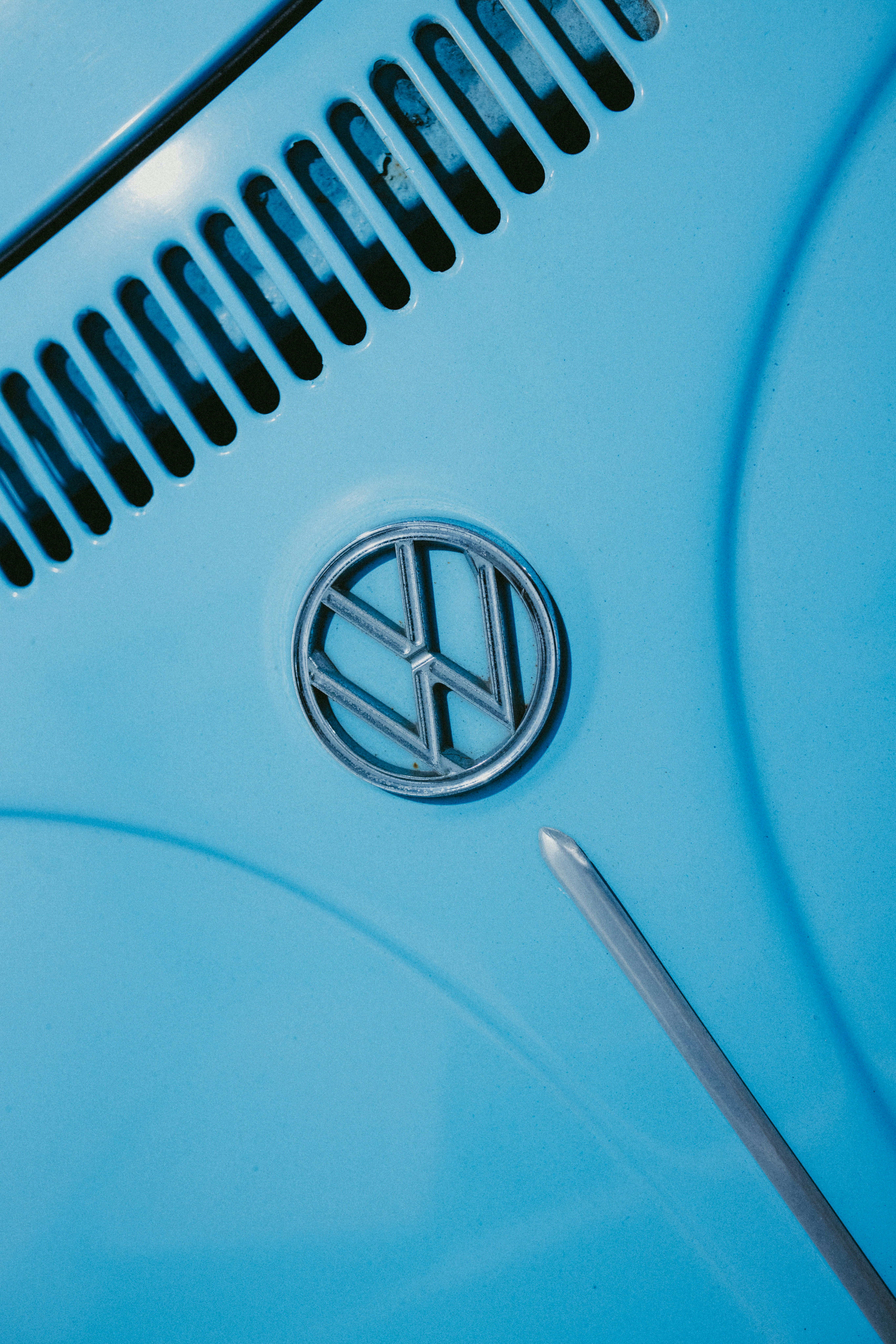 Close-up of a blue volkswagen beetle emblem