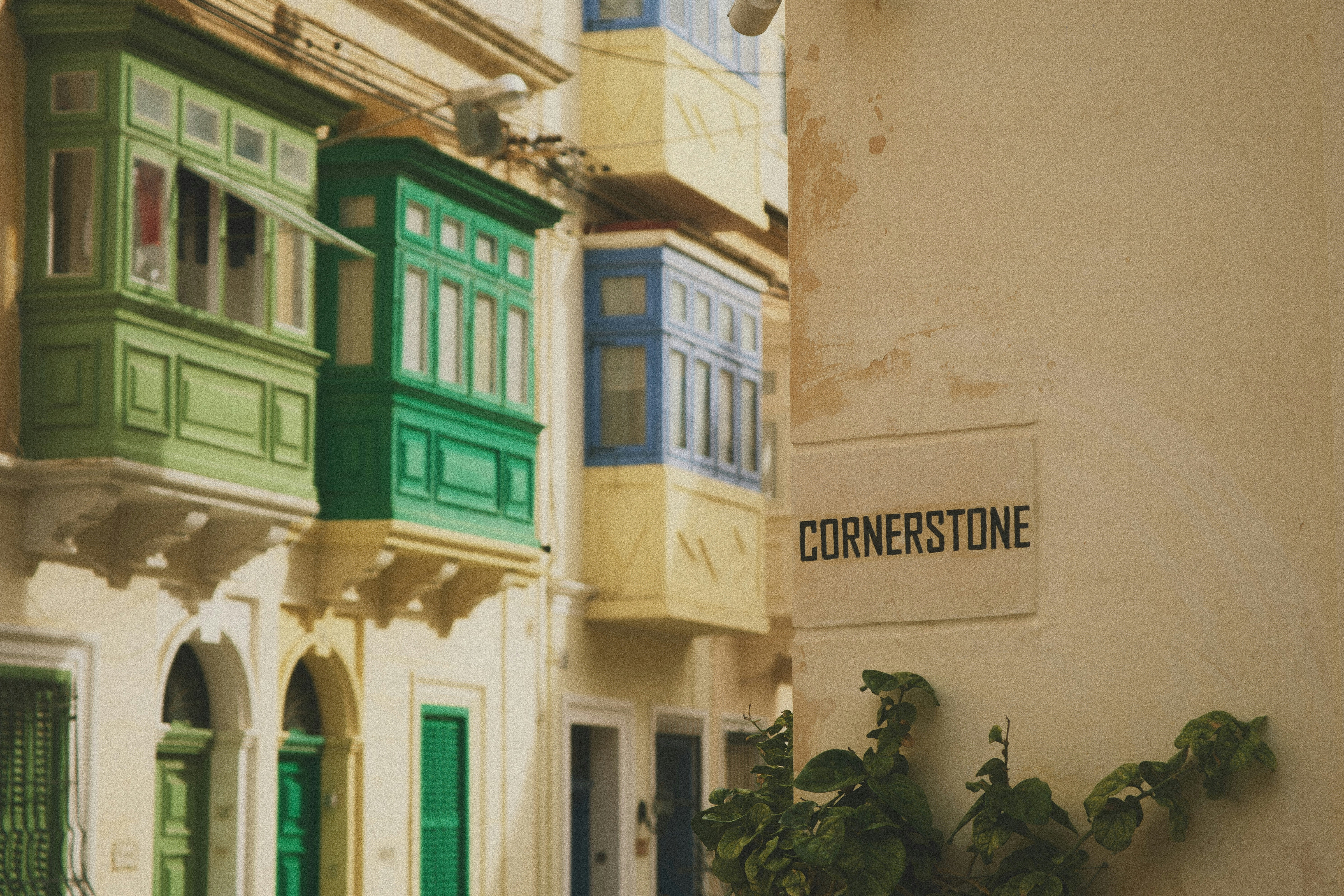 Colorful balconies on a narrow street with cornerstone sign