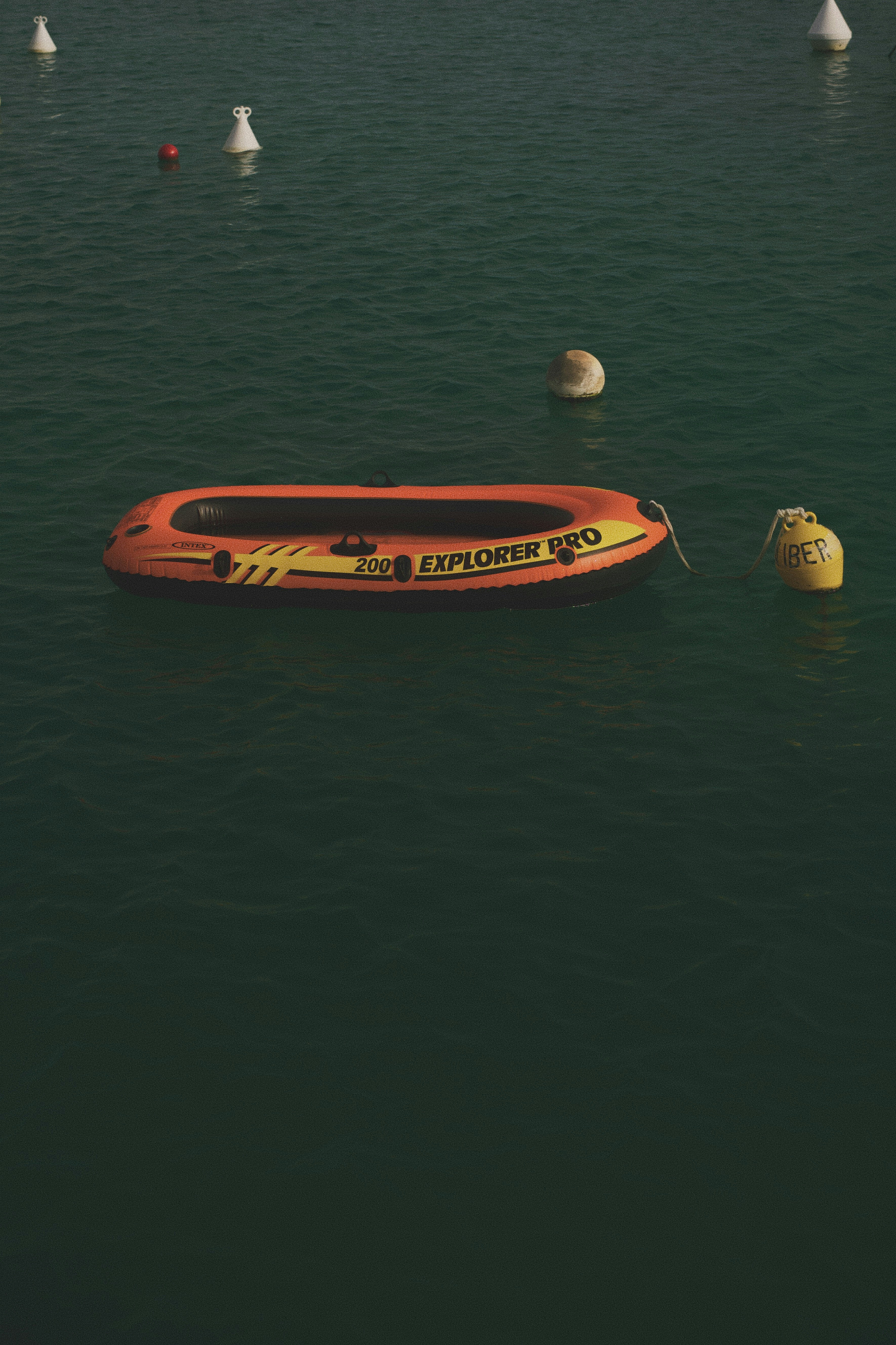 An orange inflatable boat floats on dark water.