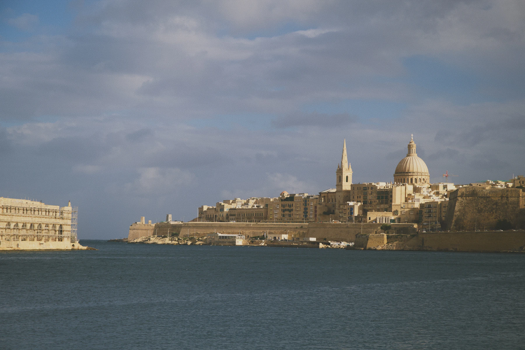 Valletta's fortified skyline, cathedral dome and spire seen across the harbour