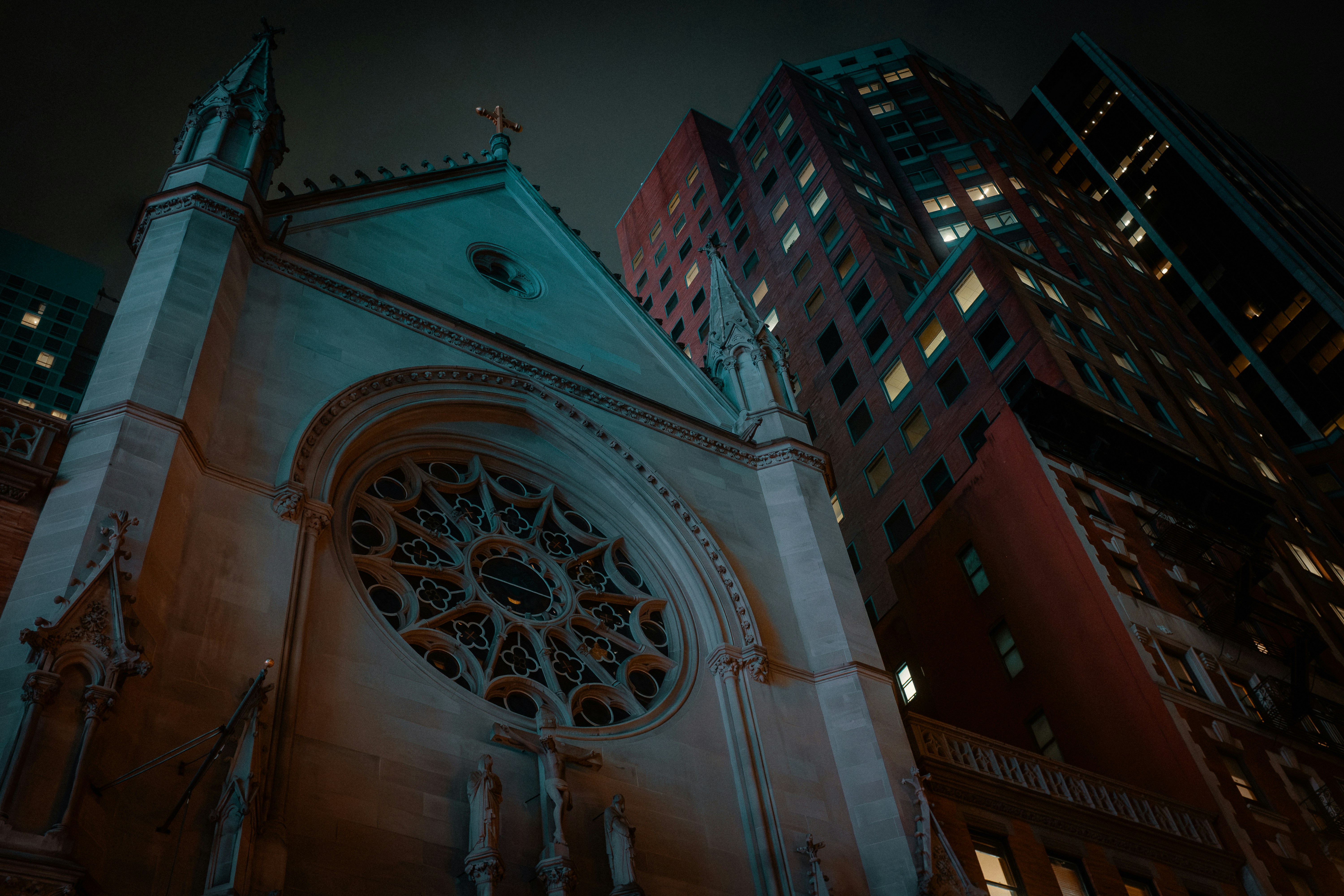 Gotische Kathedrale neben modernen Wolkenkratzern bei Nacht