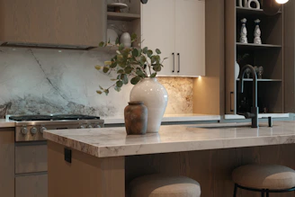 Modern kitchen island with decorative vases and faucet.