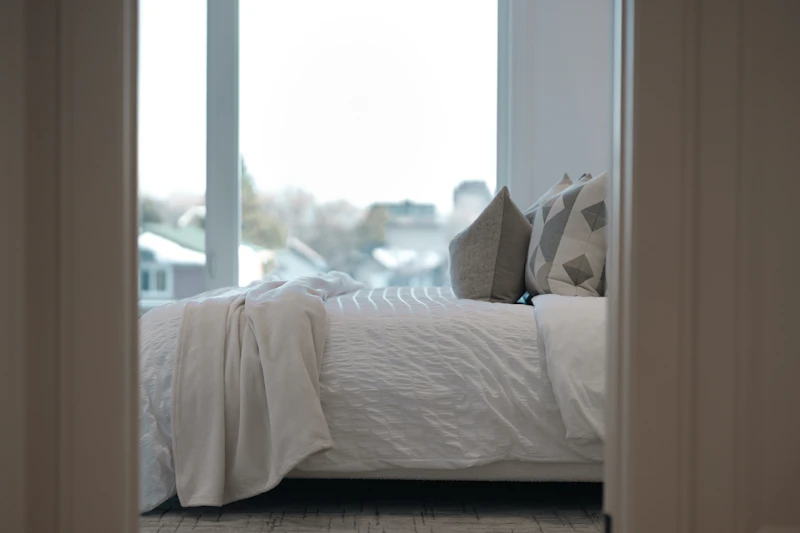 Letto rifatto con cura, con cuscini e una coperta