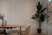 Elegant dining room with large plant and table.