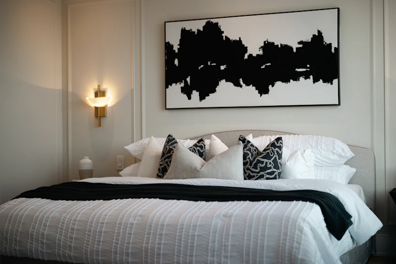 Quarto real contemporâneo com parede escura e arte abstrata