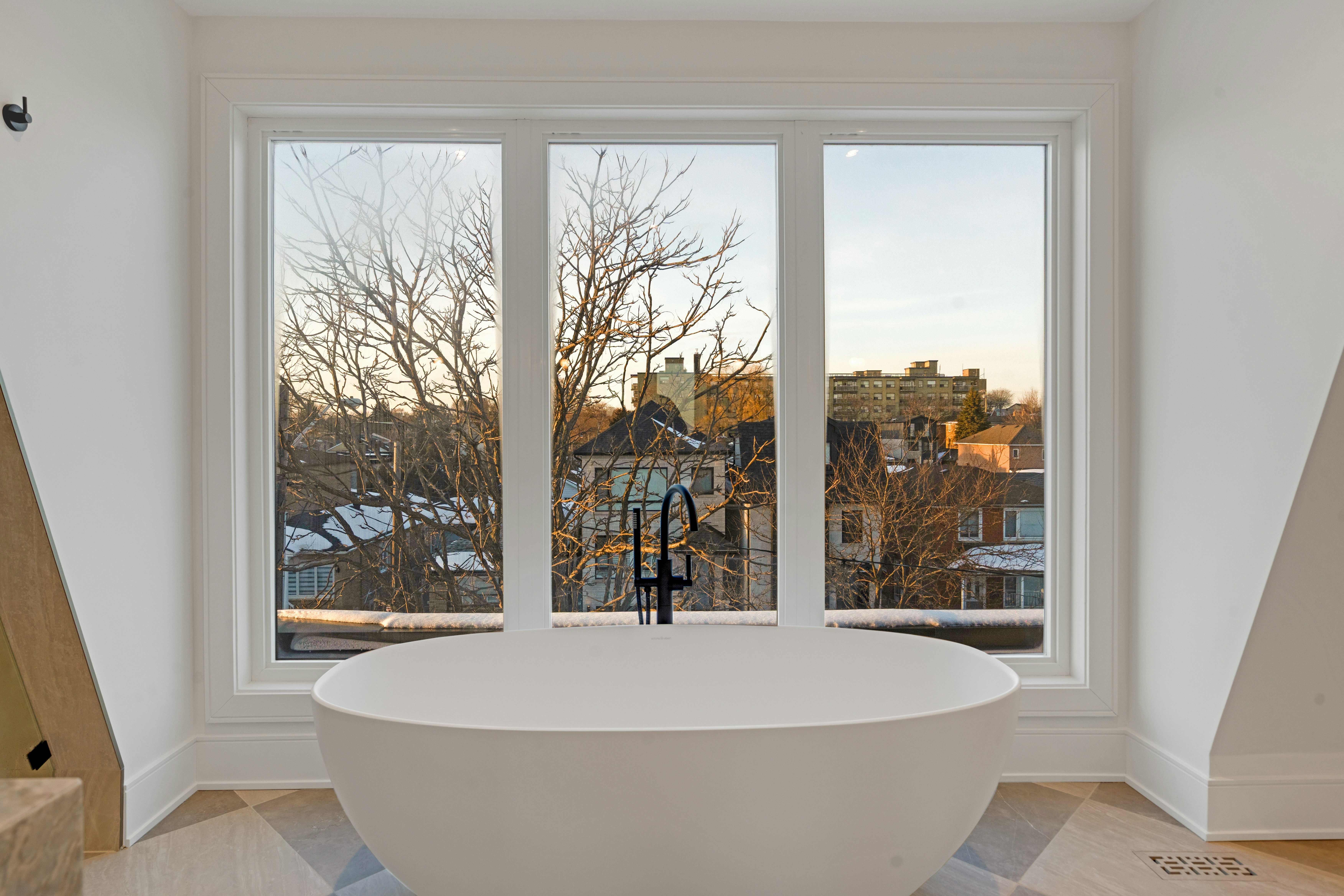 Modern bathroom with freestanding tub and large window