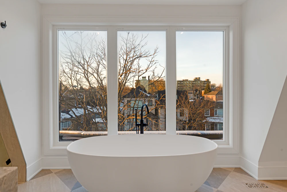 Freestanding tub set by a large window