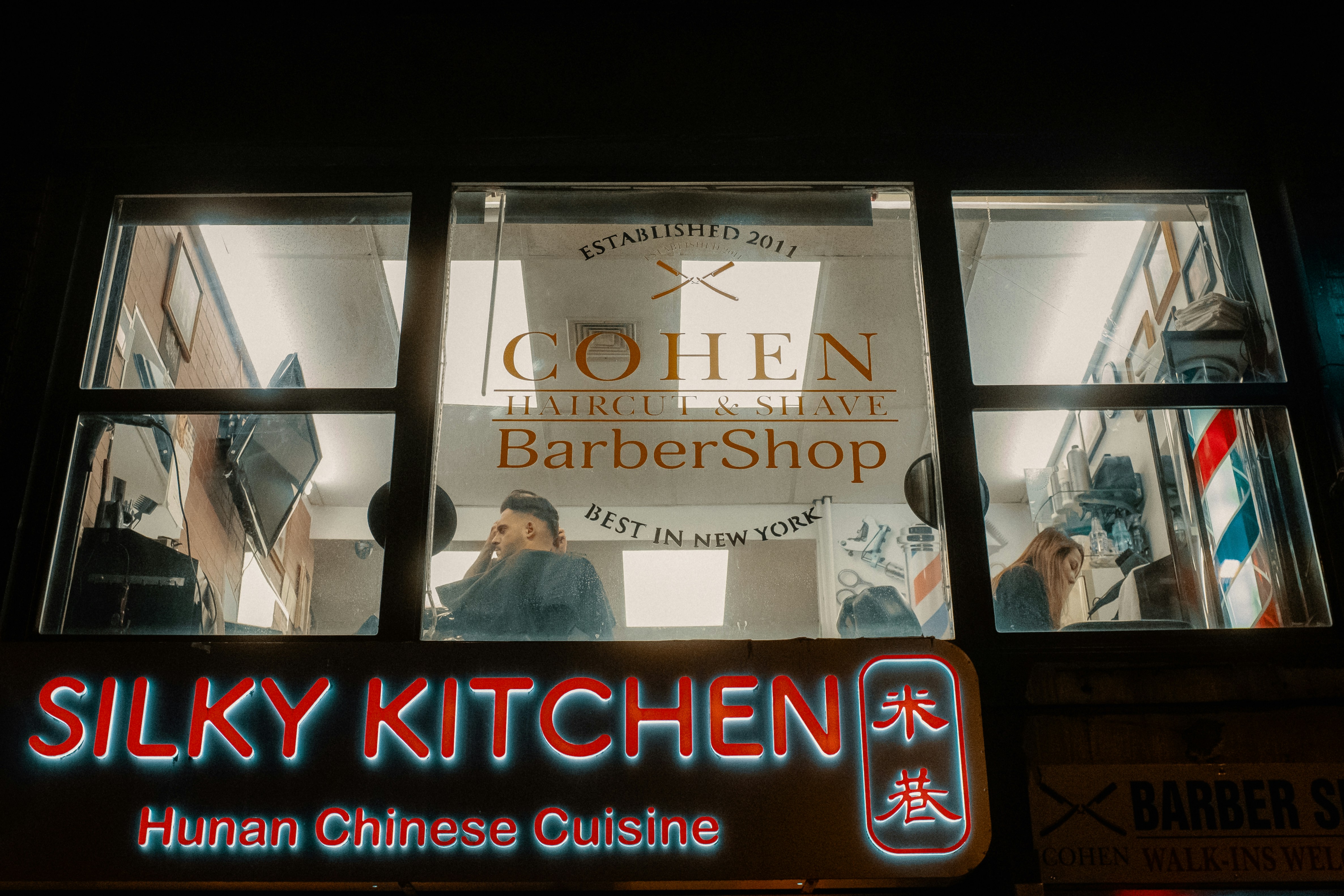Barbershop- und Restaurantfenster bei Nacht