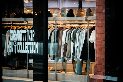 Clothes displayed on racks inside a store window