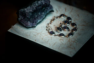 Amethyst jewelry and raw crystal on textured paper