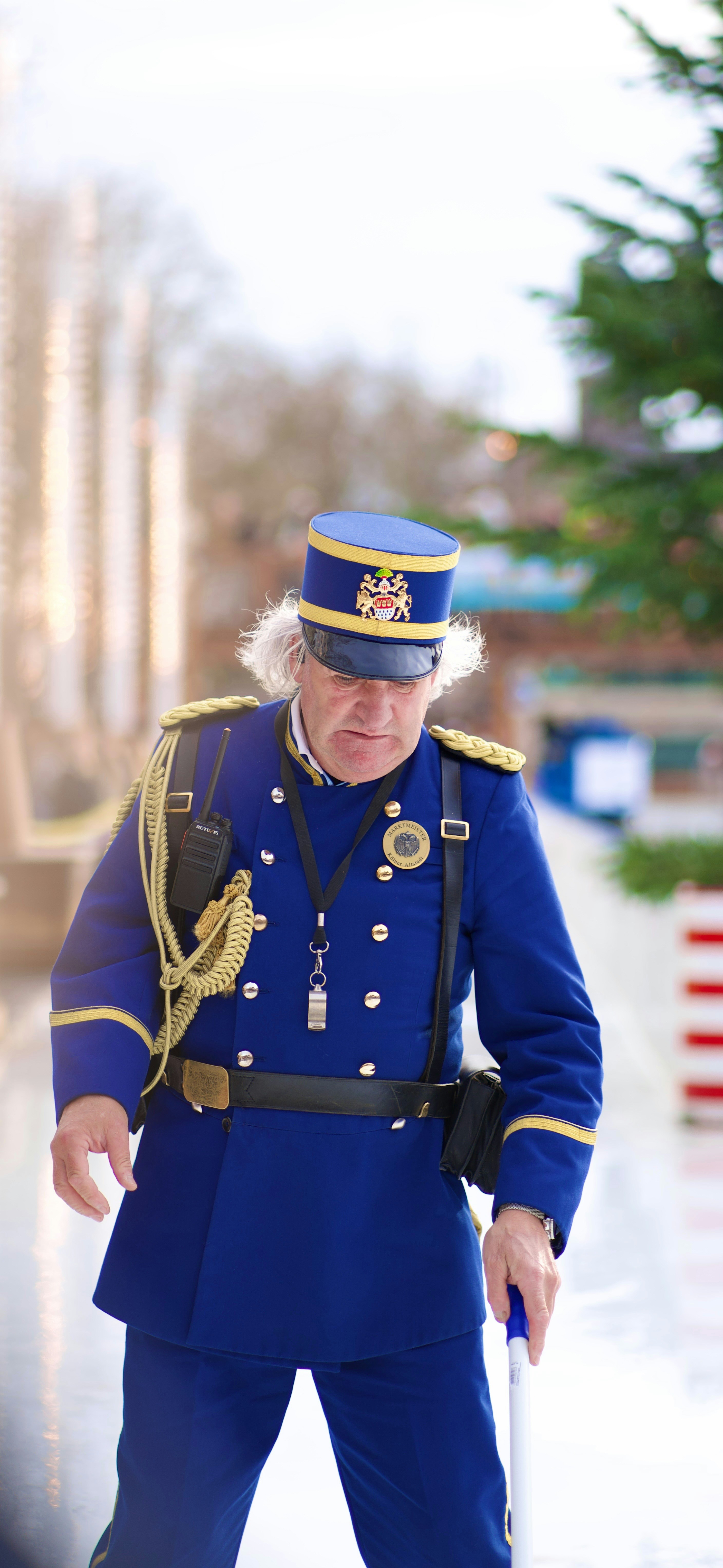 Mann in einer formellen blauen Uniform mit goldenem Rand.