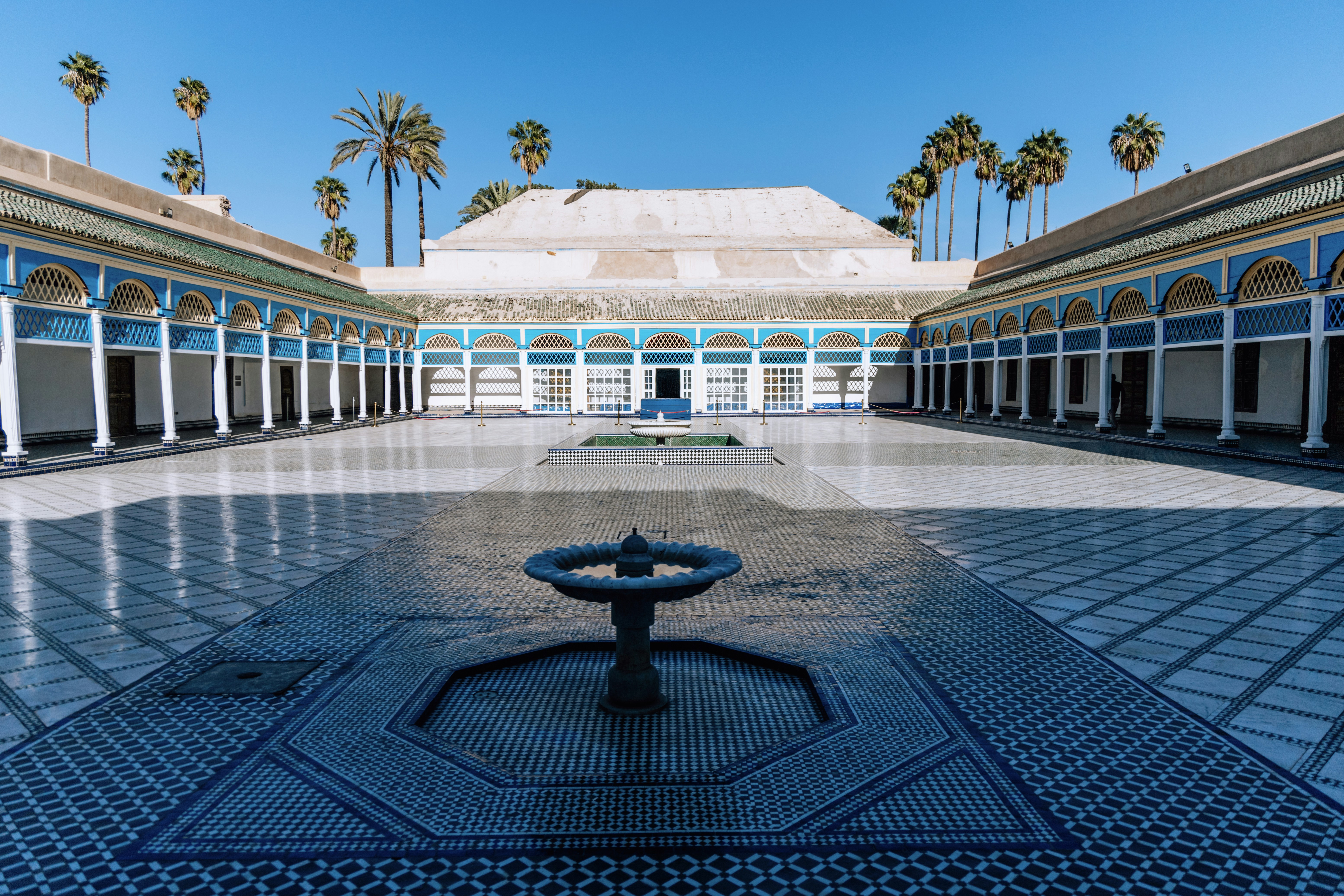 Courtyard with fountain and tiled walls, palm trees