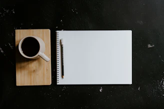A cup of coffee and notebook with a pencil
