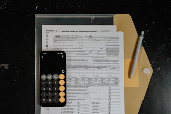 Calculator and pen on tax forms
