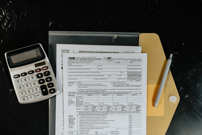 A calculator and tax forms on a desk, representing the Local School Support Tax and personal property tax abatements at issue