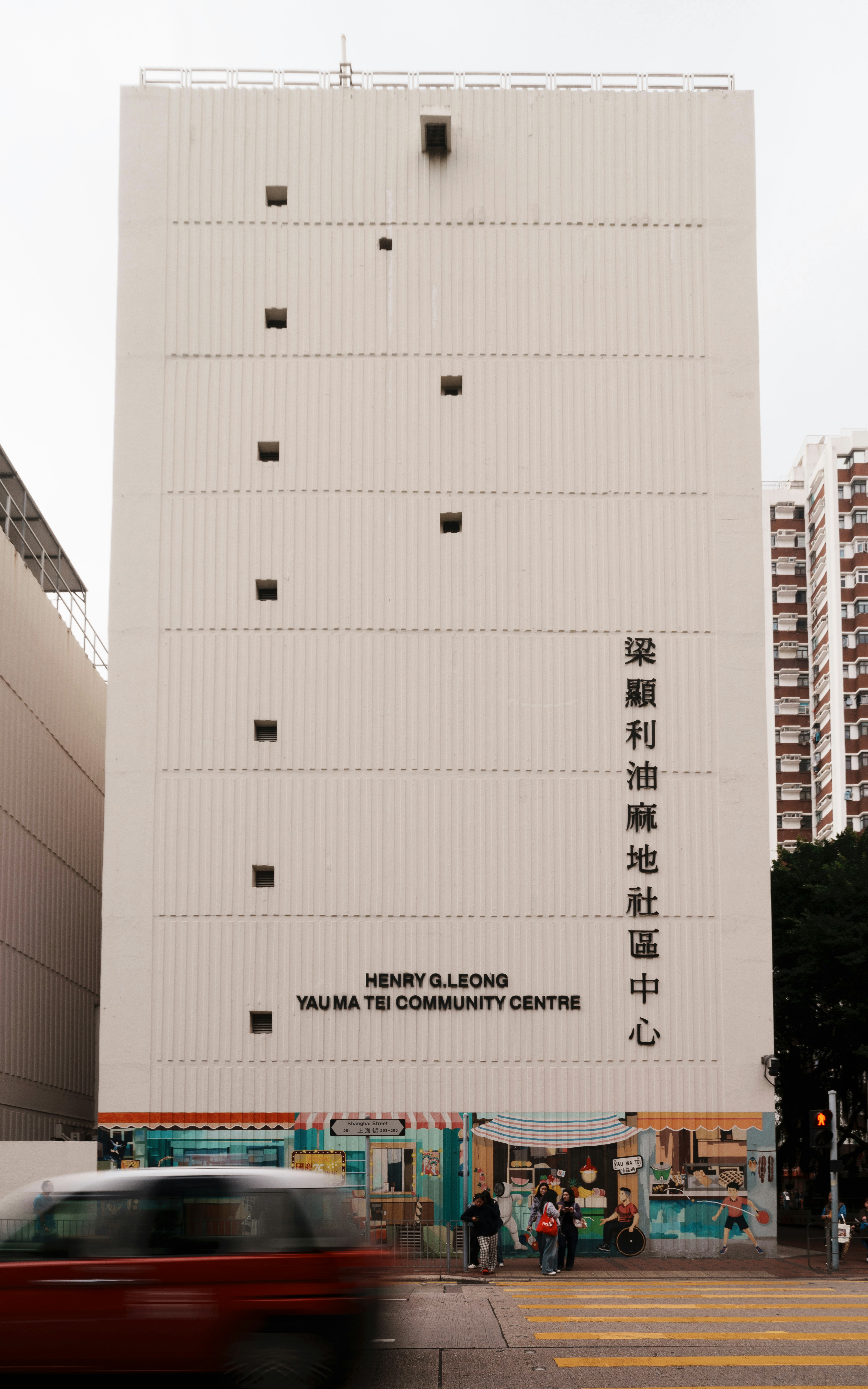 White community centre building with windows and signage.