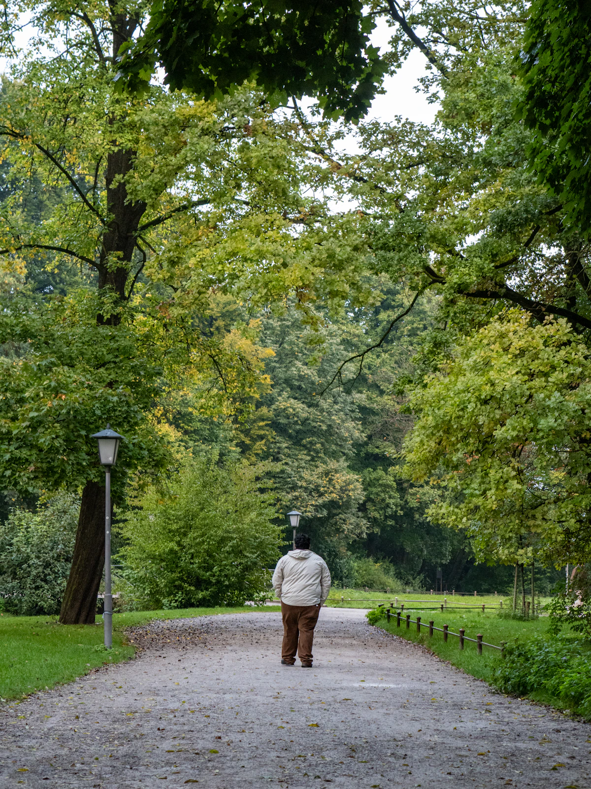 Person walking on a gravel path in sunlight