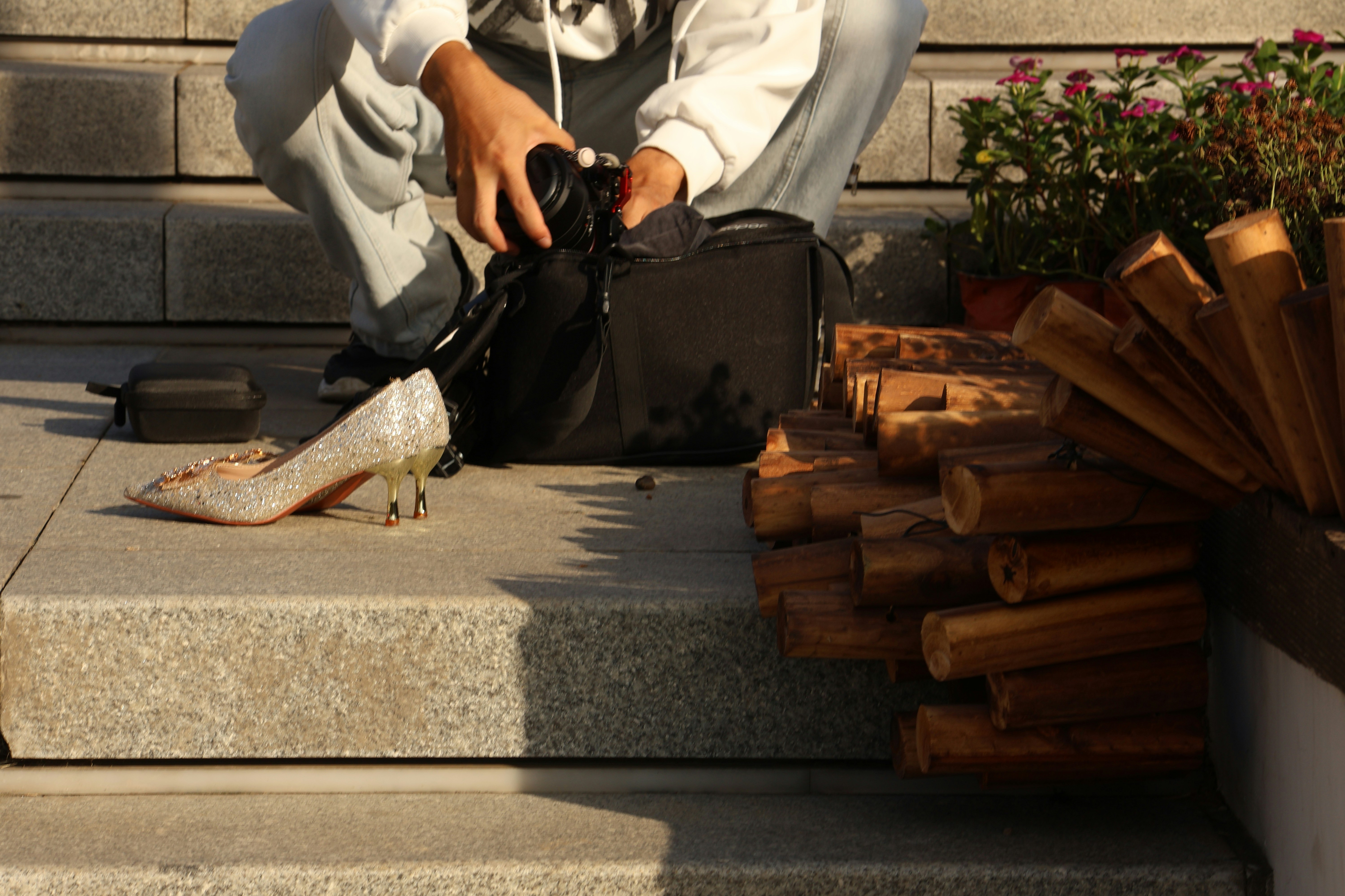 Person with camera and high heel shoe on steps.
