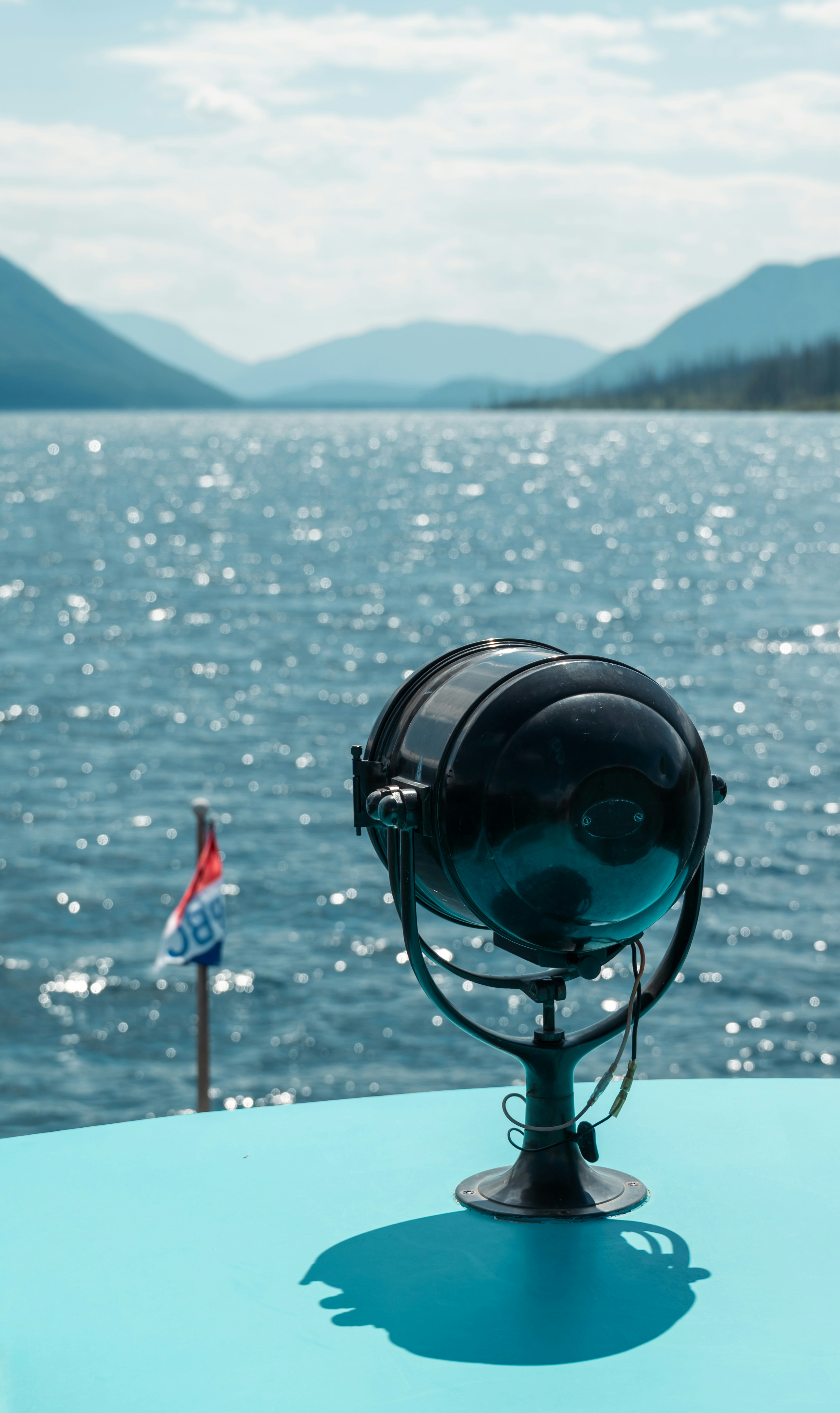 Holofote em um barco com lago e montanhas