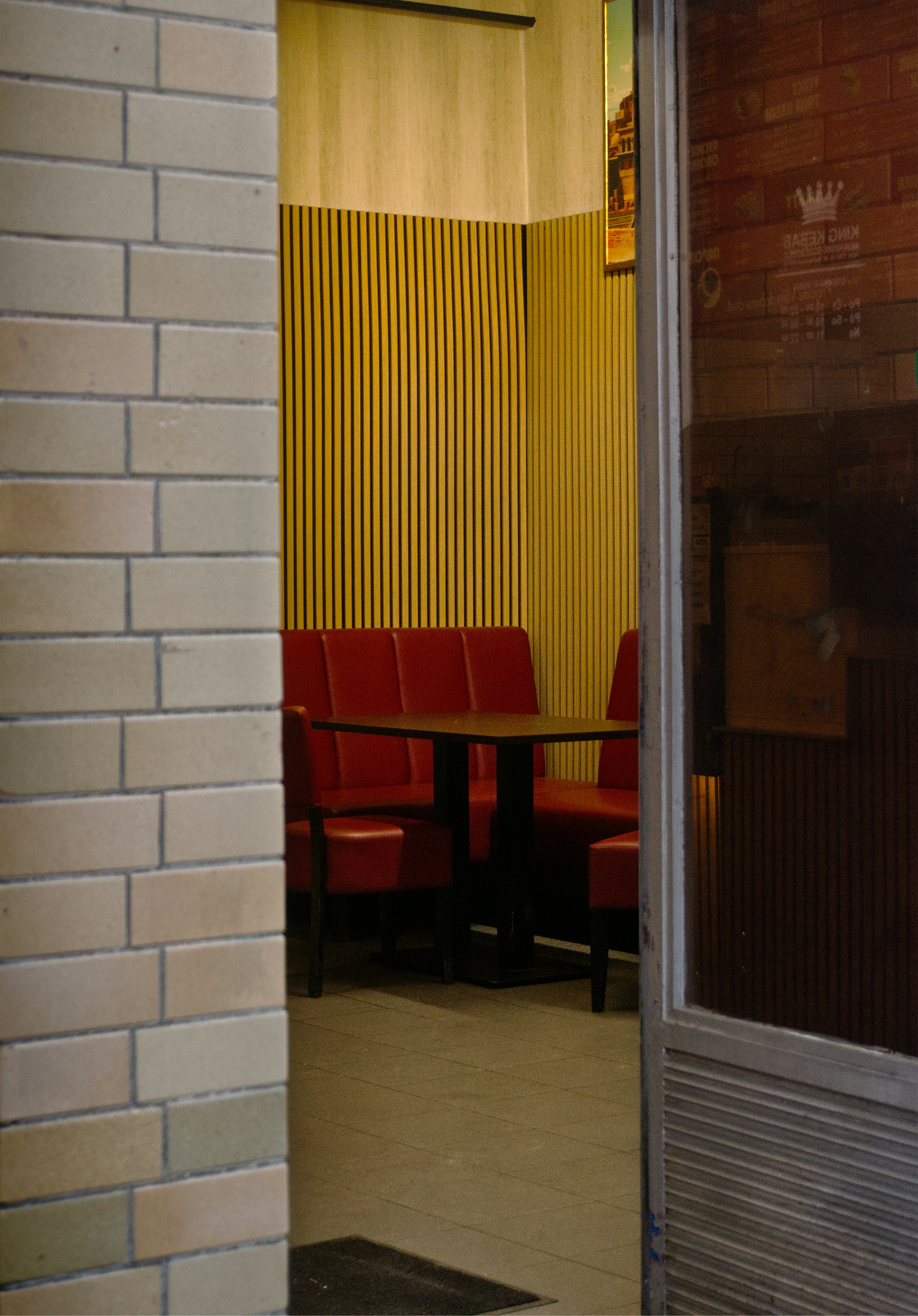 Cabinas y mesas rojas en un ambiente de cafetería.