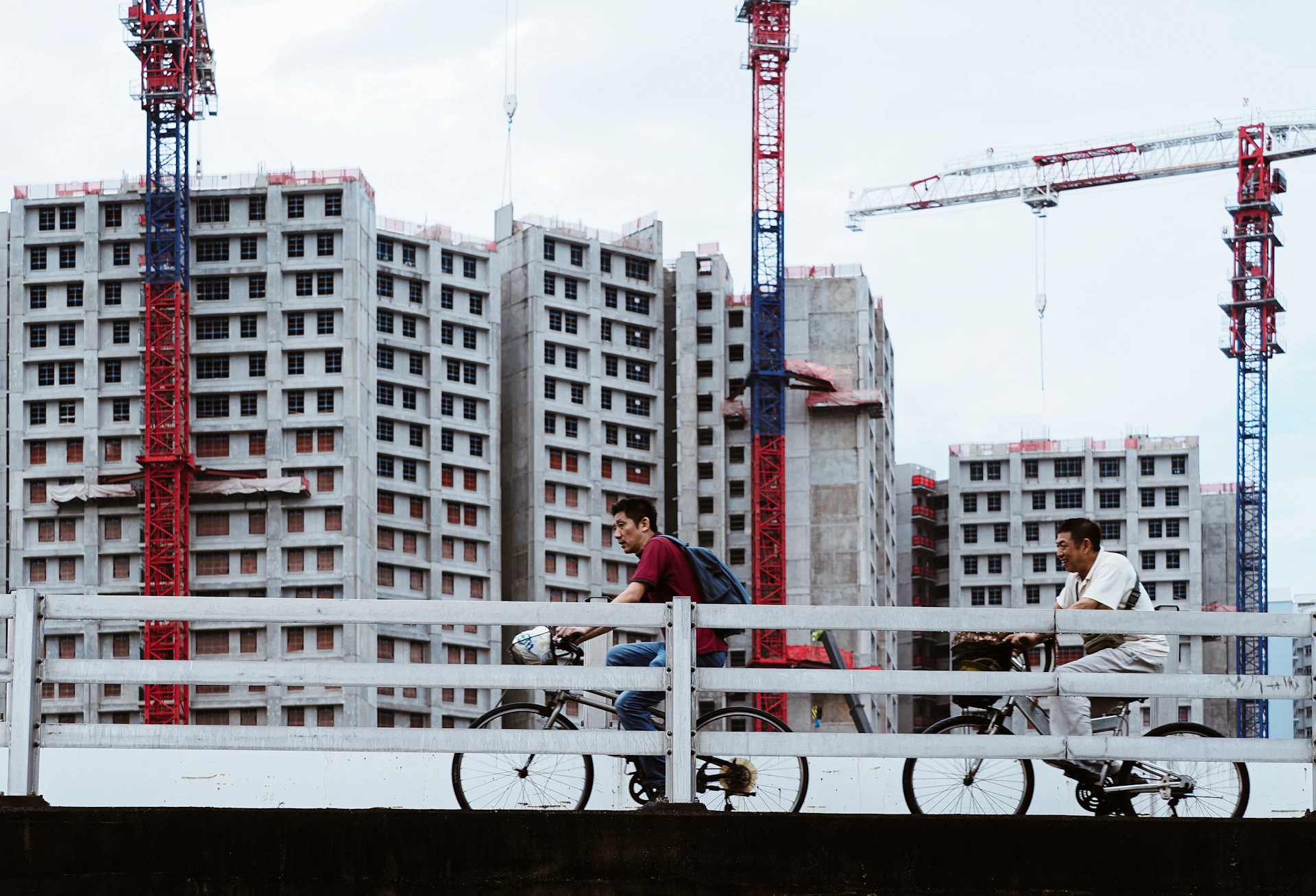 Two men on a bridge with construction site behind