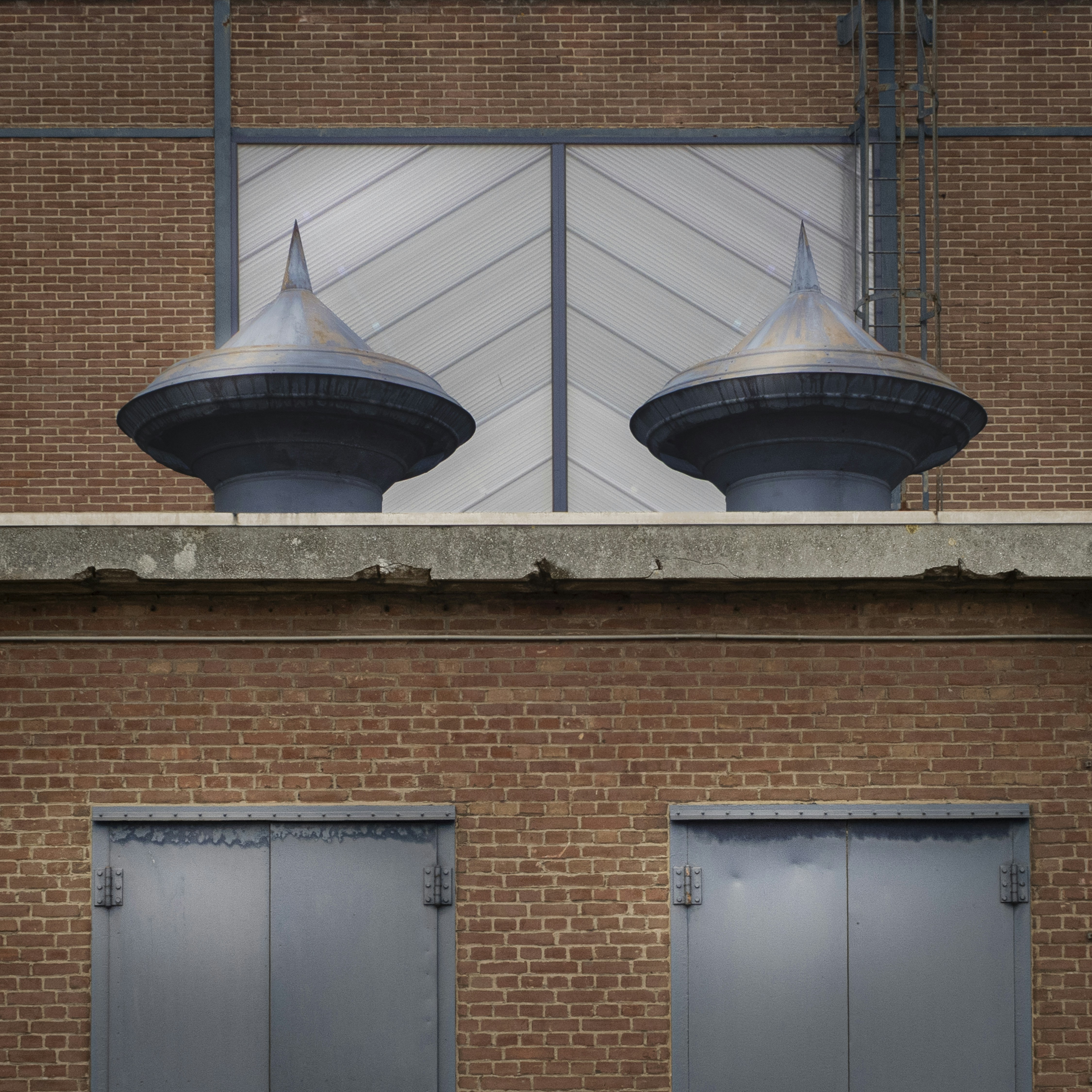 Two ornate metal domes on a brick building