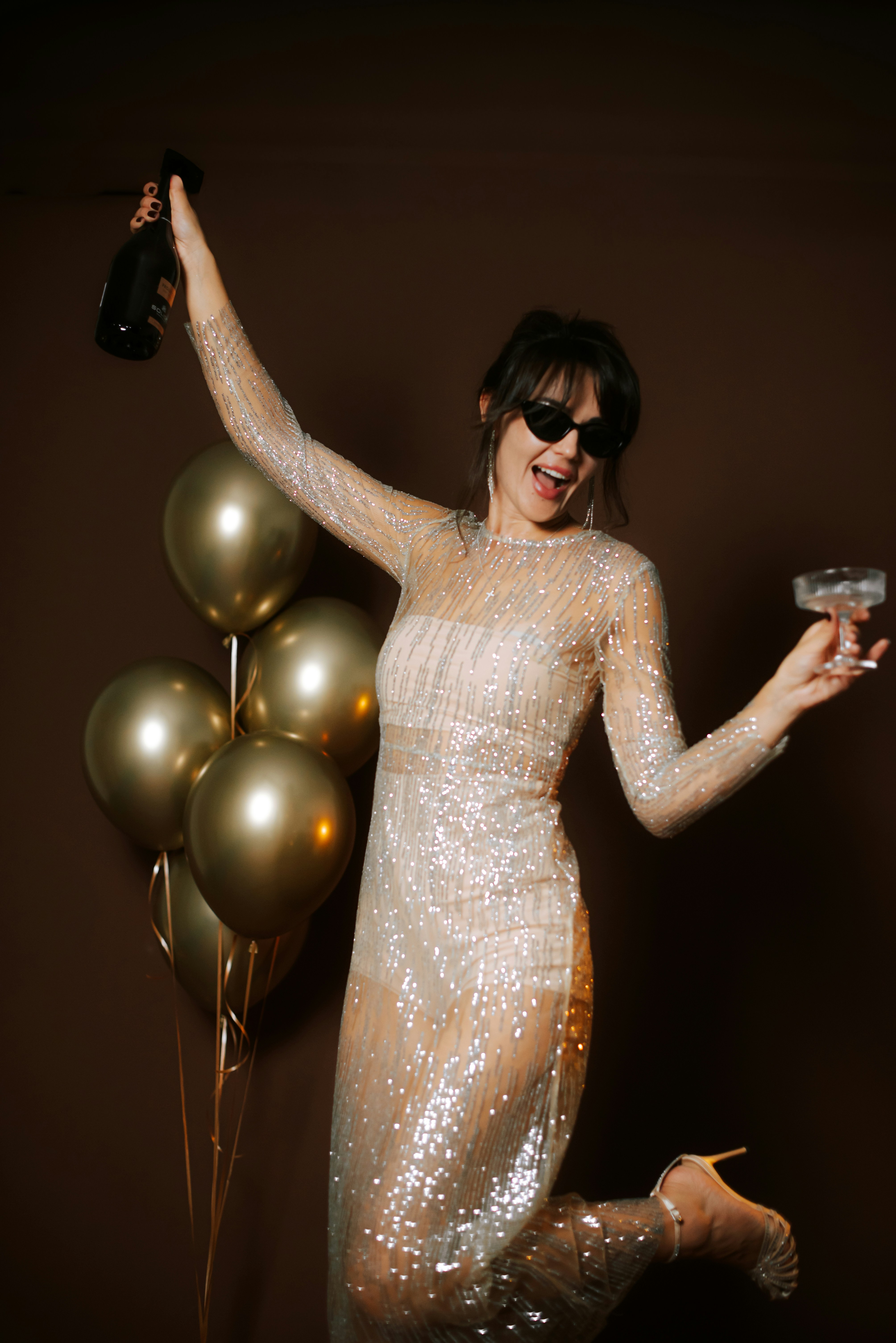 Woman in sparkly dress celebrating with champagne