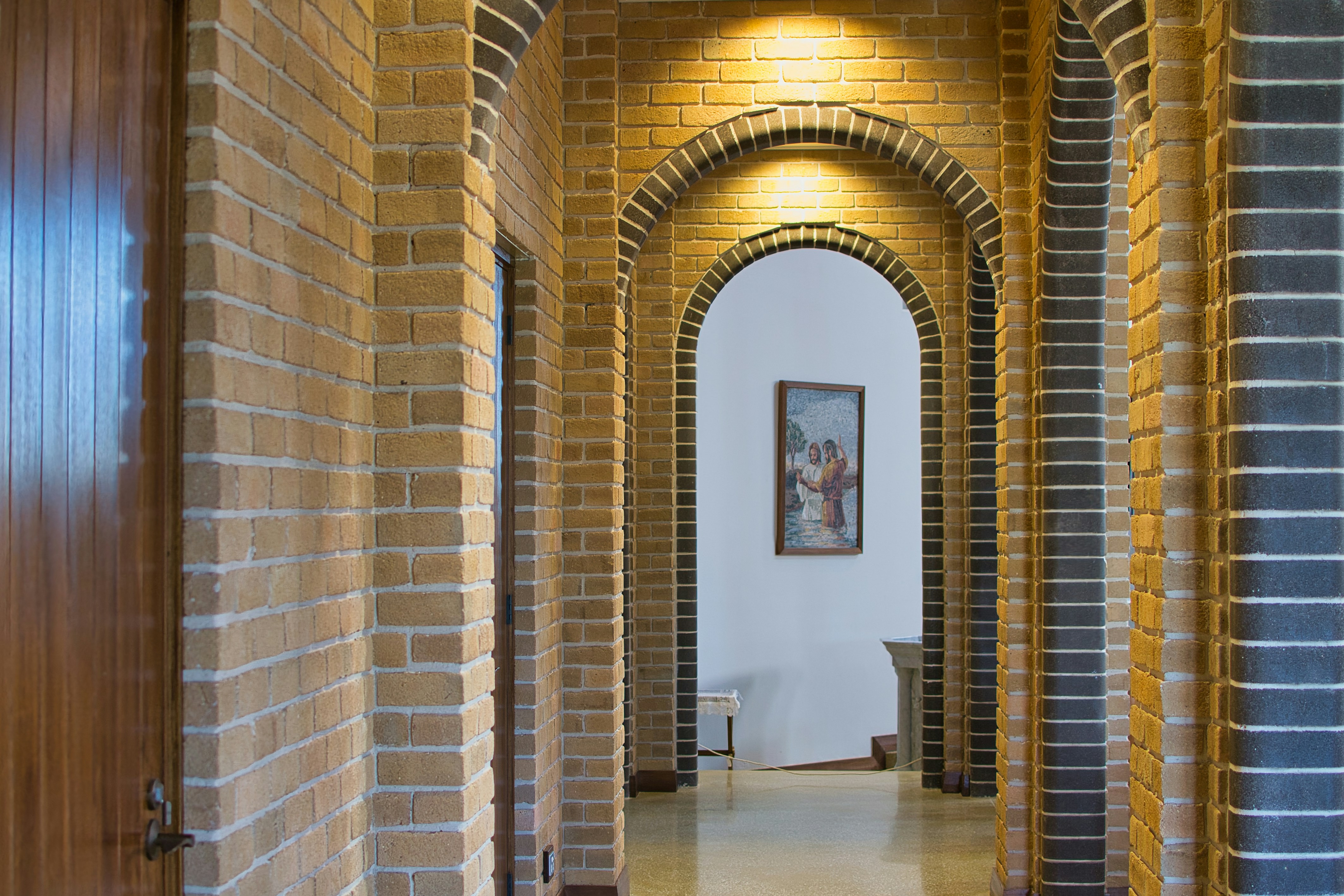 Arched hallway with brick walls and artwork