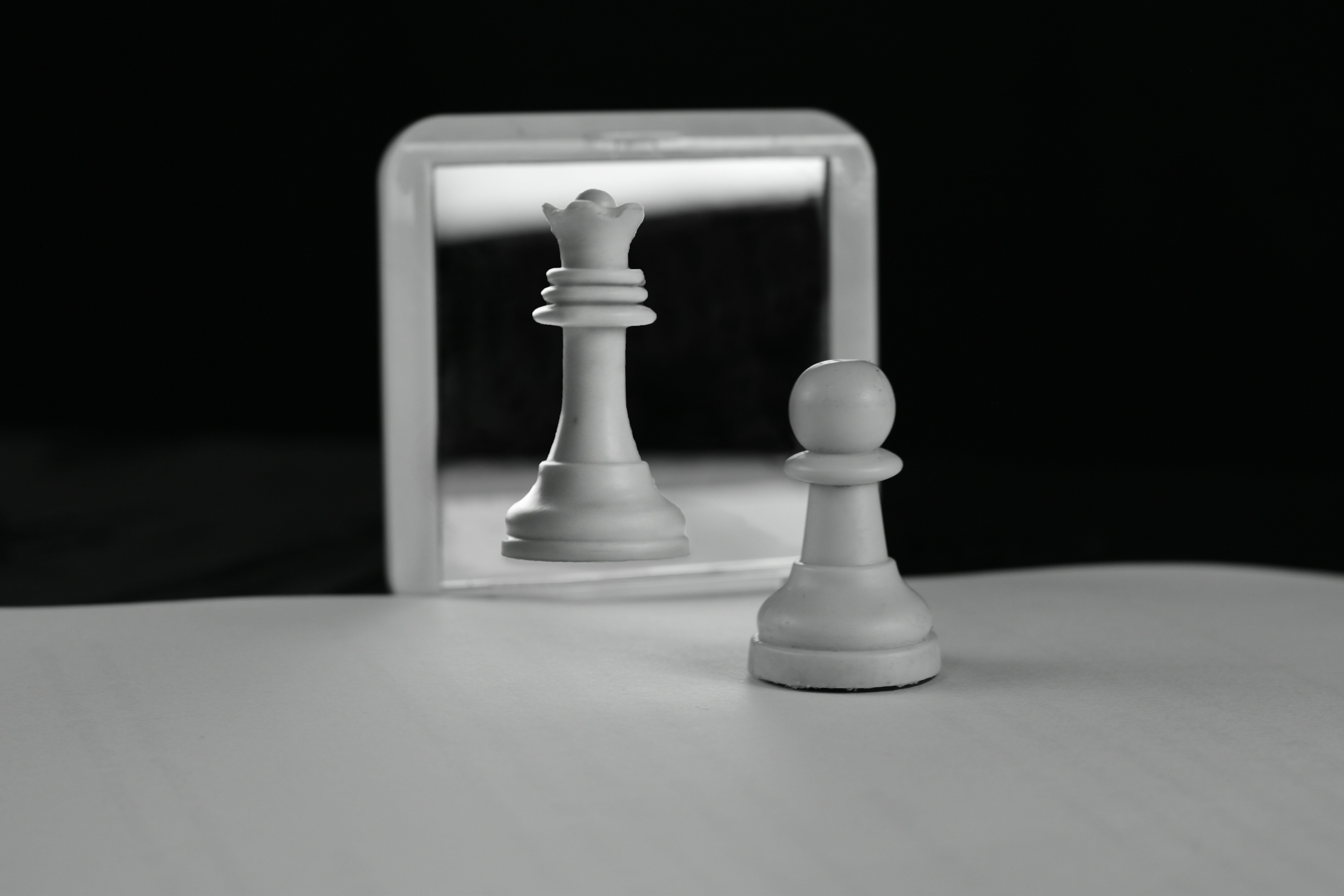 A chess pawn reflects as a queen in mirror.