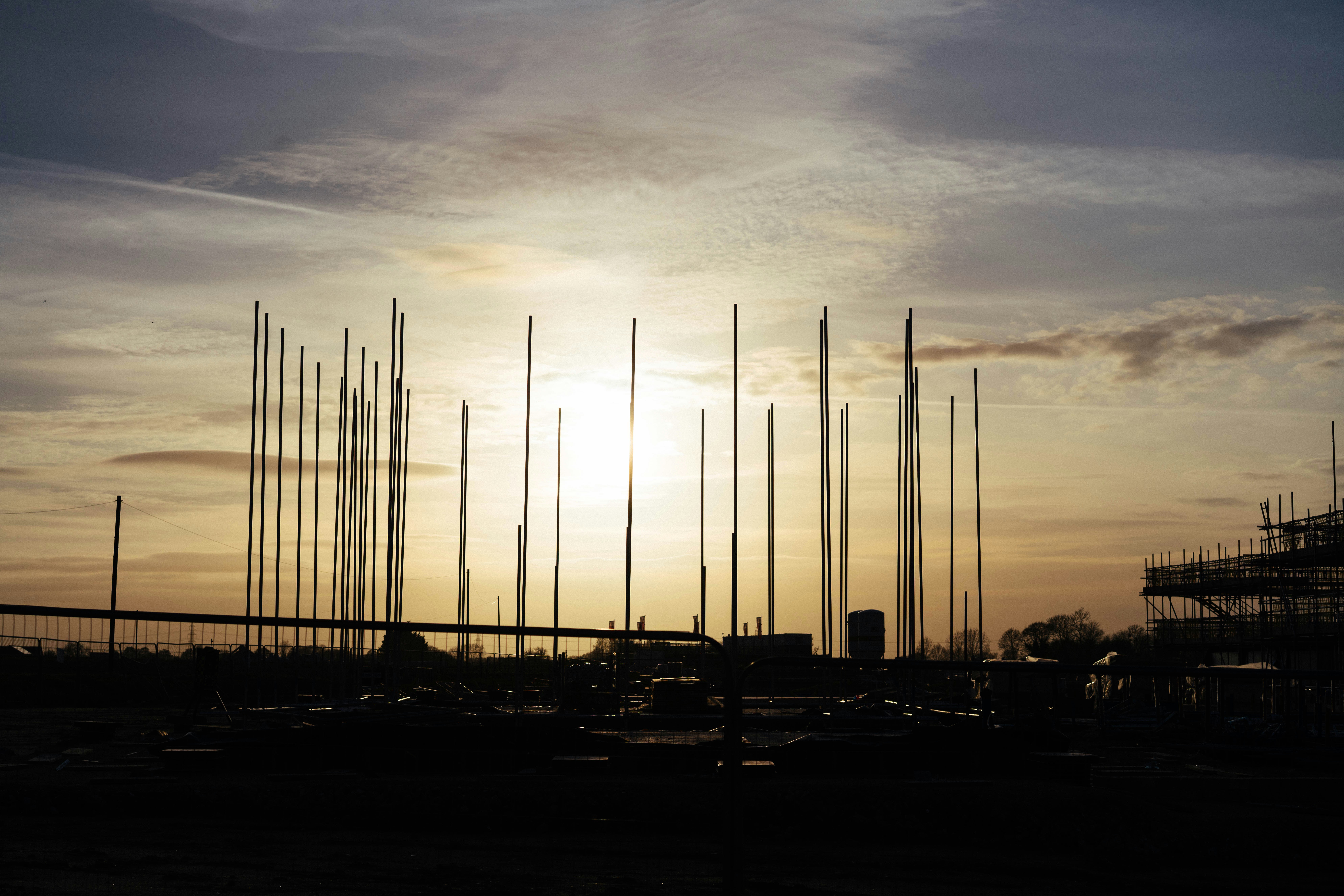 Tall poles silhouetted against a sunset sky