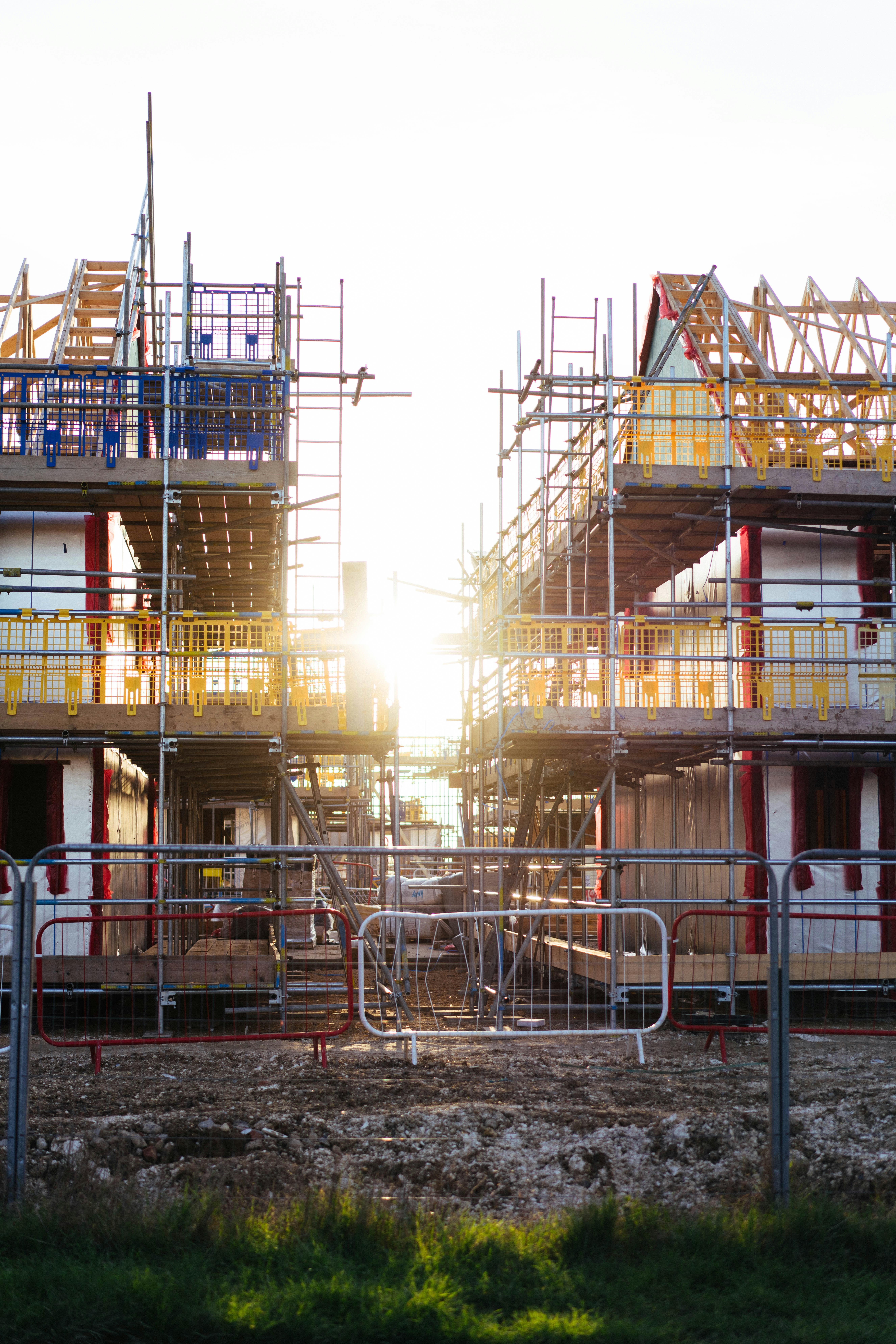 Construction de nouvelles maisons avec échafaudages et soleil.
