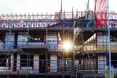 Building construction with scaffolding and sun flare.