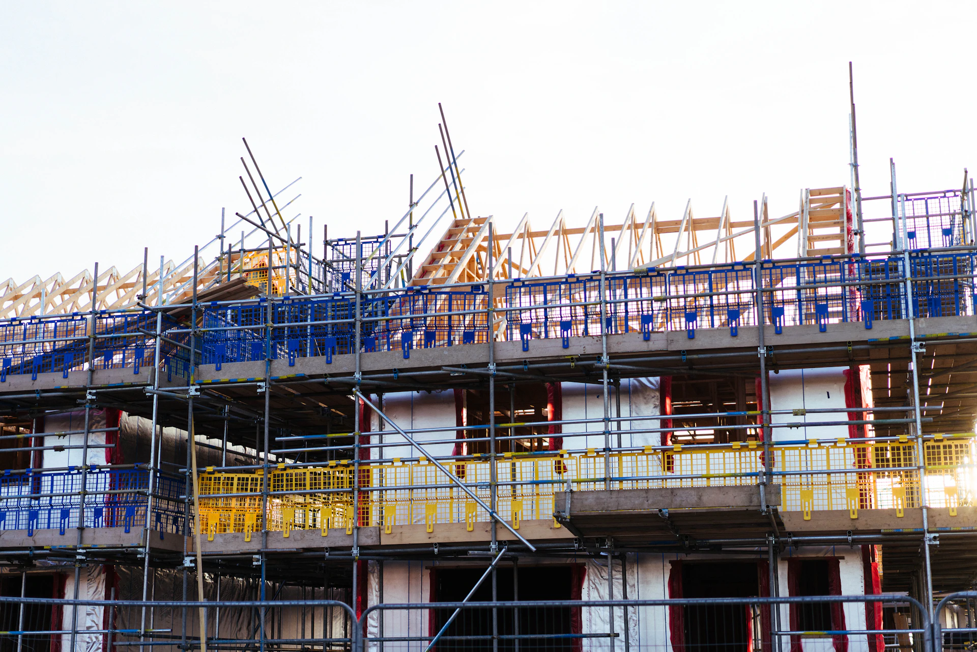 Building under construction with scaffolding and blue netting